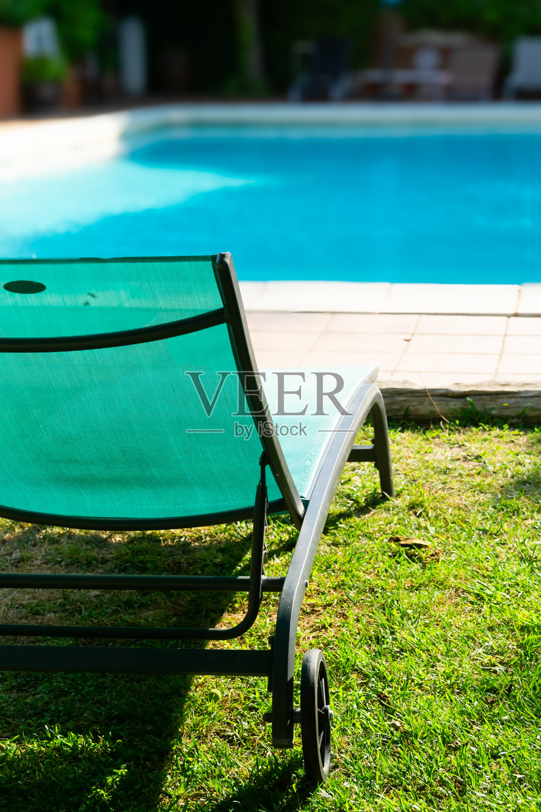 夏季游泳池旁草地上的日光浴床照片摄影图片