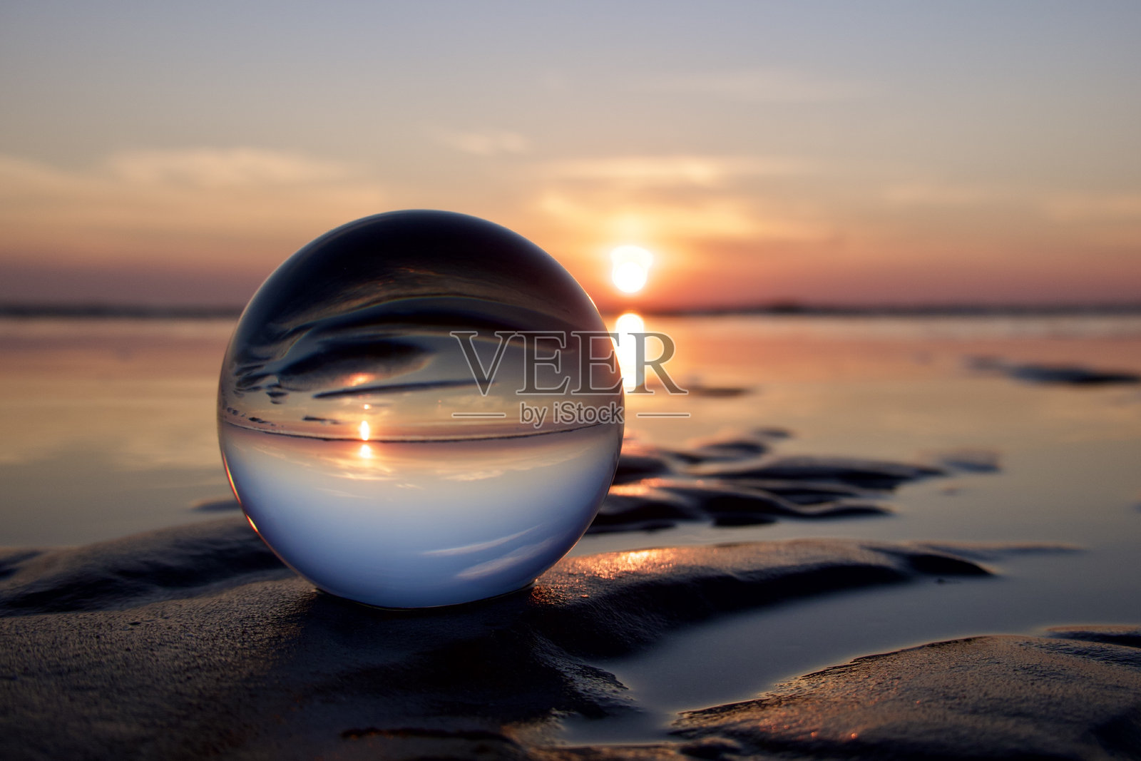 日出时分，里米尼海滩上的水晶球照片摄影图片