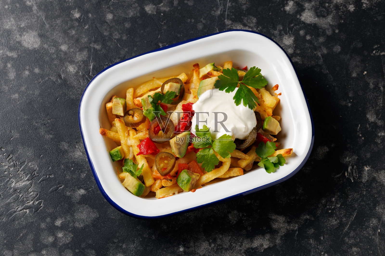 装满鳄梨、烤红椒、墨西哥胡椒和切达奶酪的素食薯条照片摄影图片