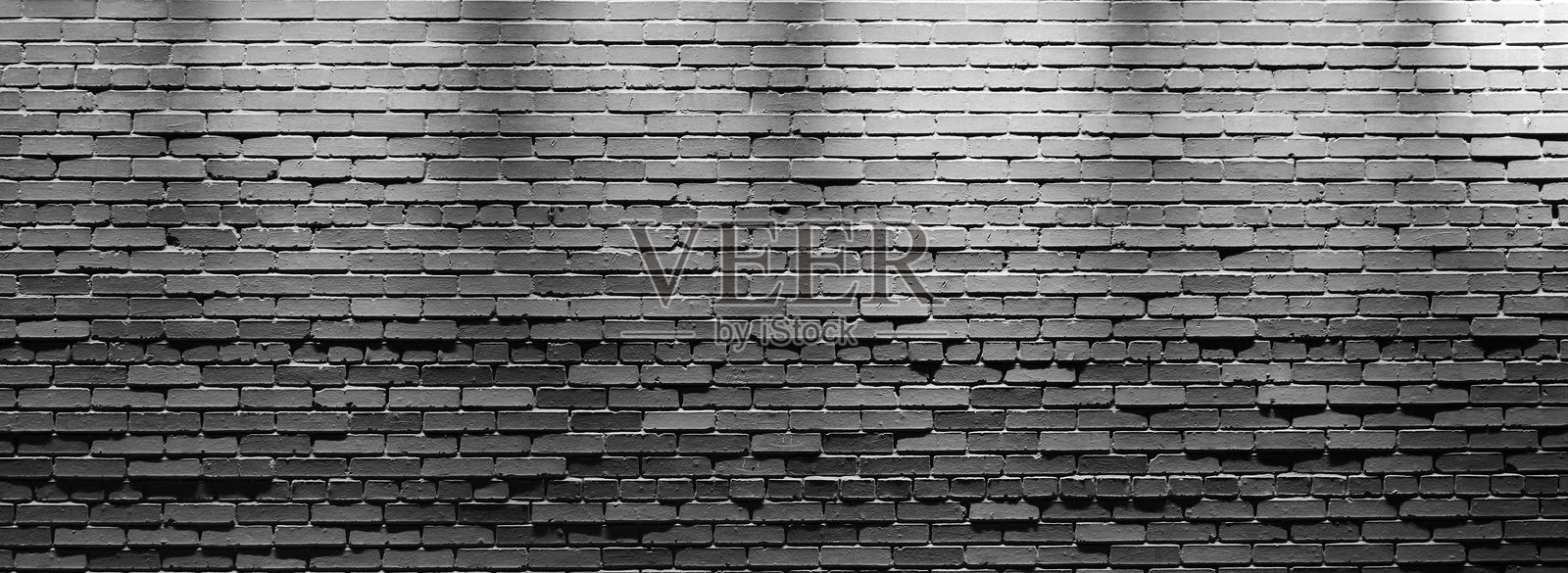 全景抽象黑色砖块背景。抽象黑色砖墙图案。粗糙的纹理和磨损的表面背景，适用于建筑装饰室内。照片摄影图片
