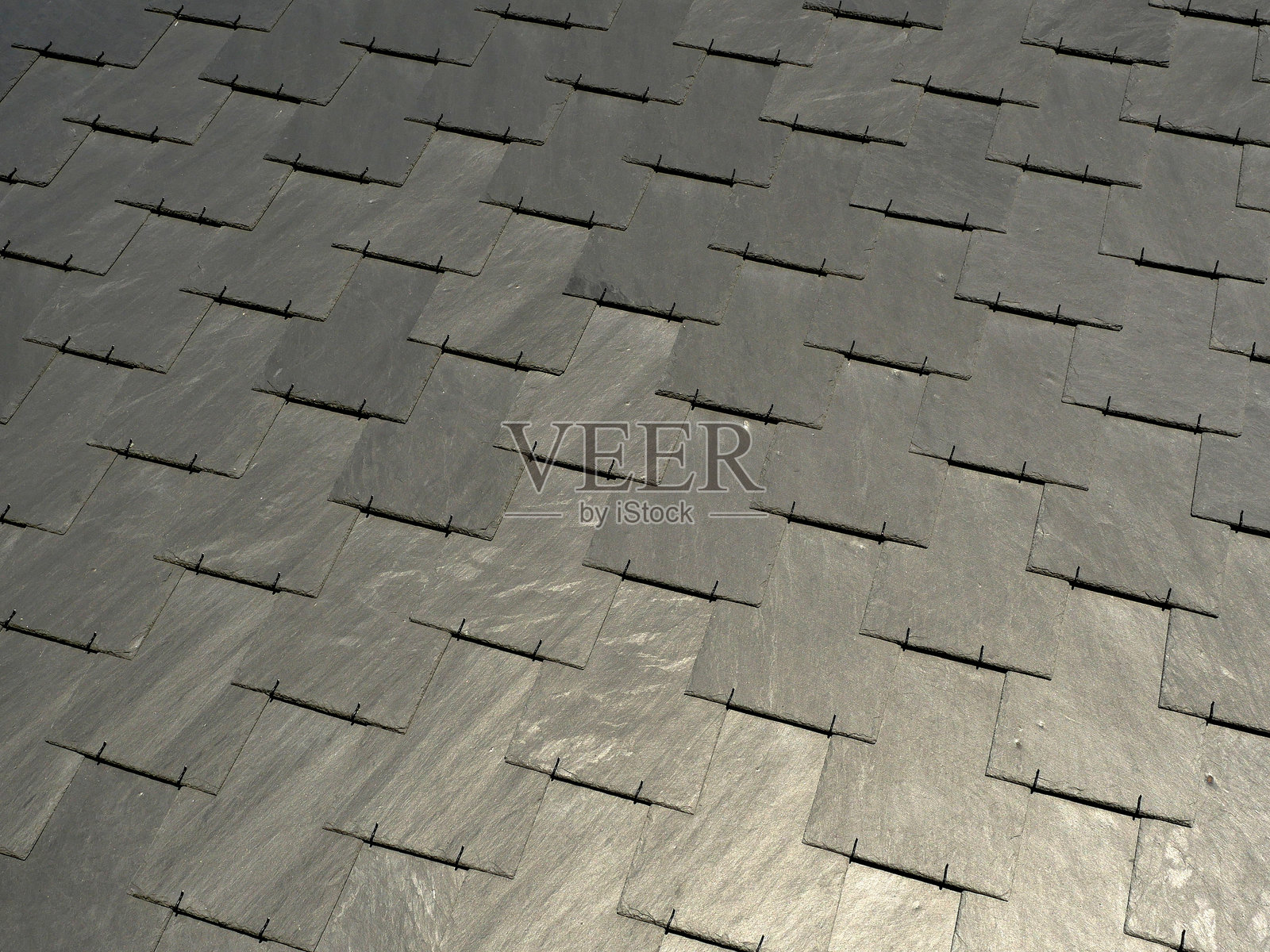 用无烟煤色板岩面板制成的屋顶瓦作为外立面装饰照片摄影图片