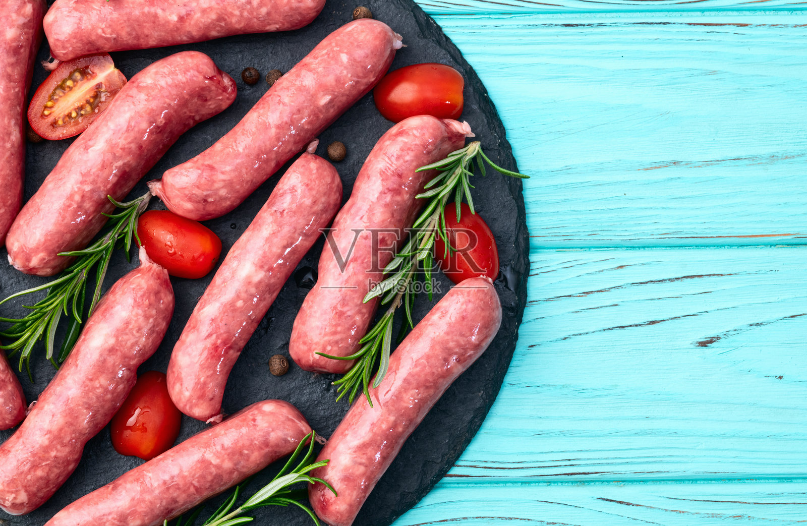 新鲜牛肉香肠配迷迭香和番茄的摄影作品。俯视图。照片摄影图片