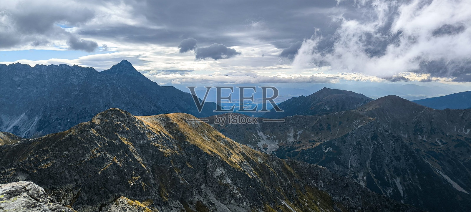 在山中徒步旅行作为一种最爱的爱好。积极的生活方式。从徒步小径欣赏塔特拉山脉和高塔特拉山的美景。山峰、山坡和山谷之间的景色。照片摄影图片