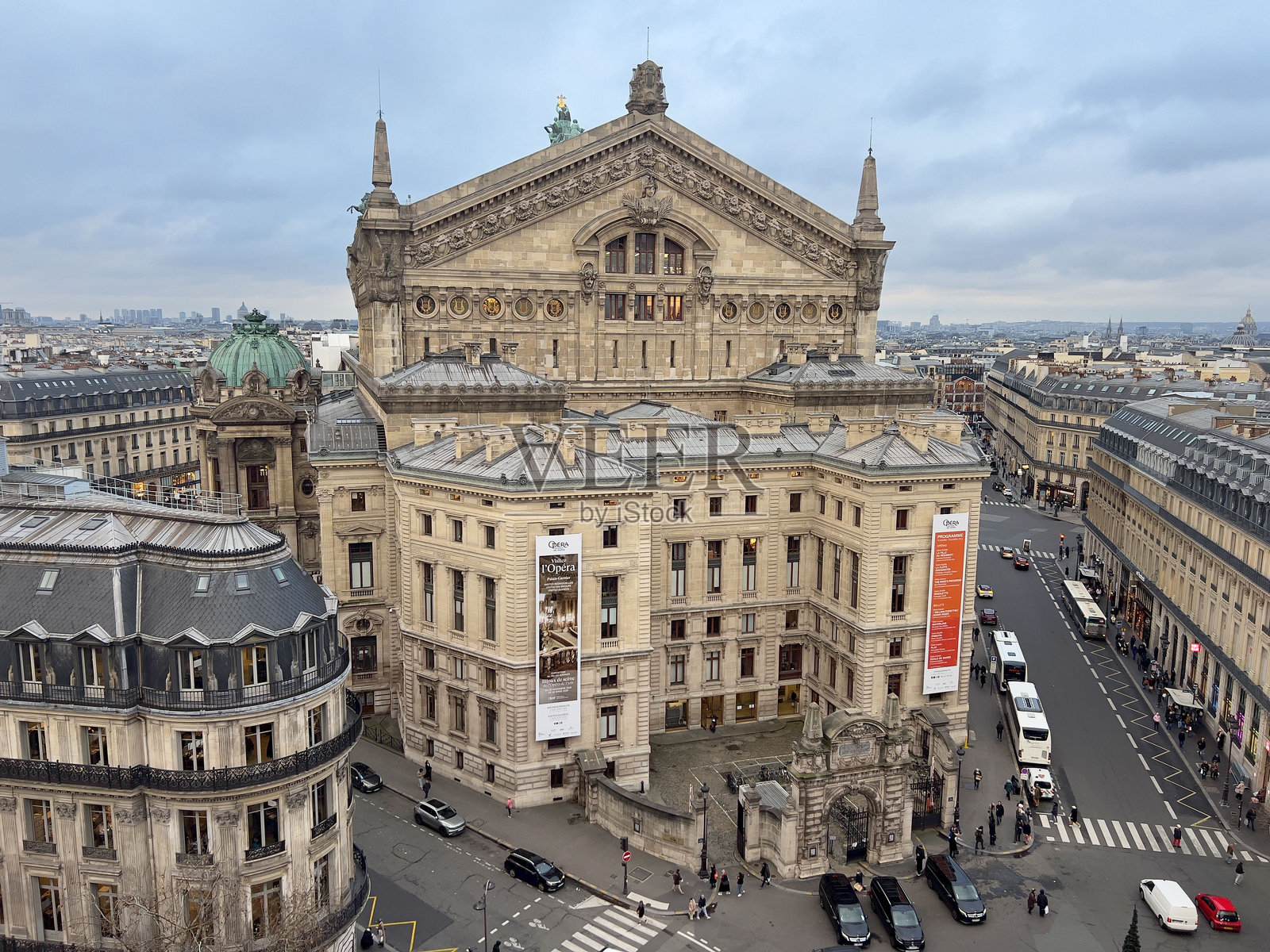 巴黎歌剧院的景观，繁忙的街道和经典建筑在阴云密布的天空下。照片摄影图片