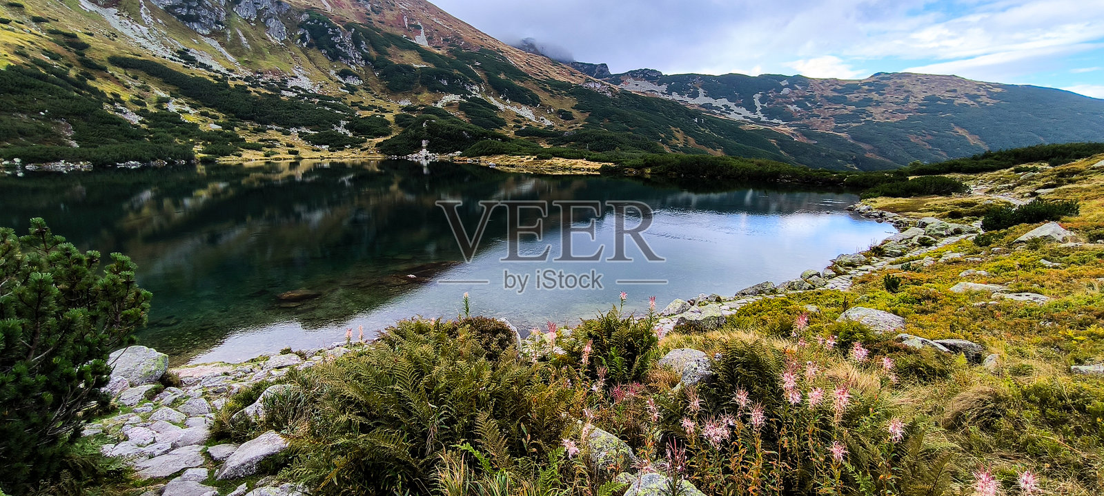 在山中徒步旅行作为一种最爱的爱好。积极的生活方式。从徒步小径欣赏塔特拉山脉和西塔特拉山的美景。山峰、山坡、湖泊和山间的山谷。照片摄影图片