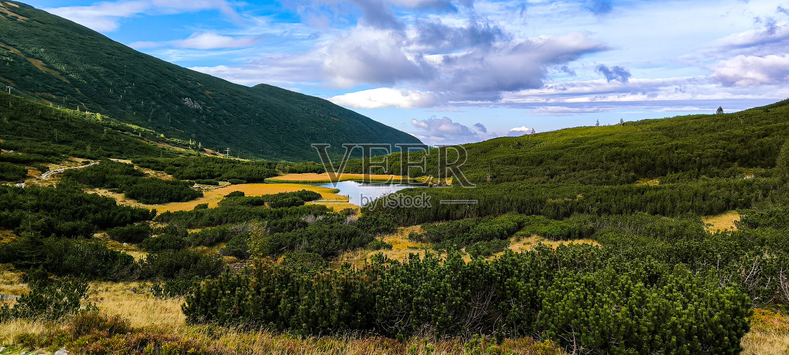 在山中徒步旅行作为一种最爱的爱好。积极的生活方式。从徒步小径欣赏塔特拉山脉和西塔特拉山的美景。山峰、山坡、湖泊和山间的山谷。照片摄影图片