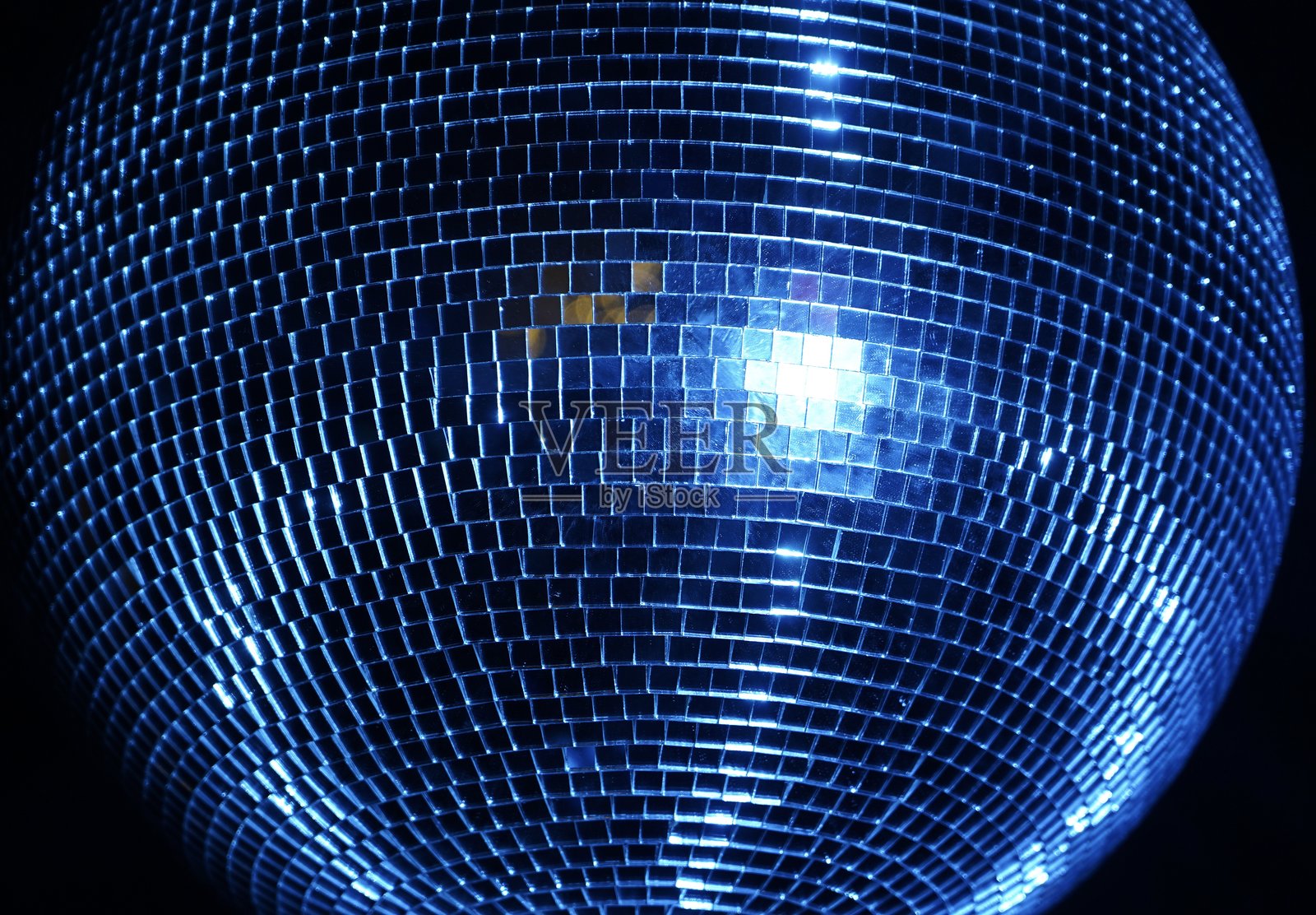 迪斯科球是悬挂在黑暗房间天花板上的镜面球体，缓慢旋转并被照亮，以在周围物体上产生“星空”效果。照片摄影图片