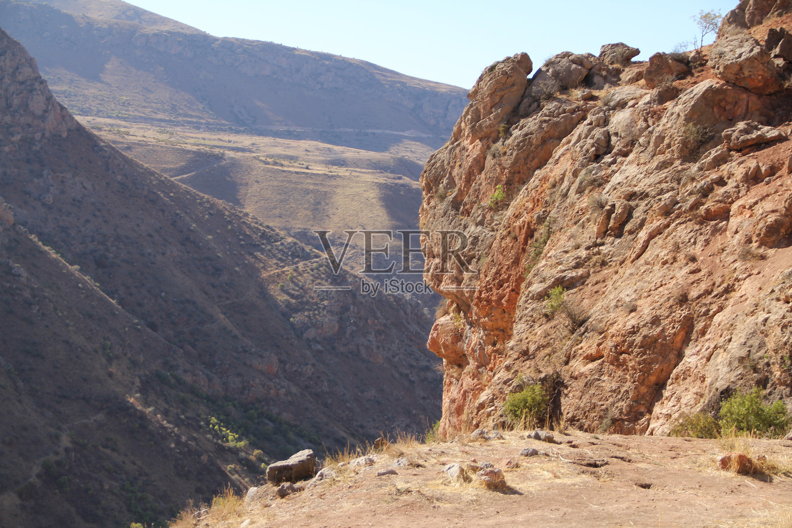 陡峭悬崖和遥远山谷的岩石峡谷风景。照片摄影图片