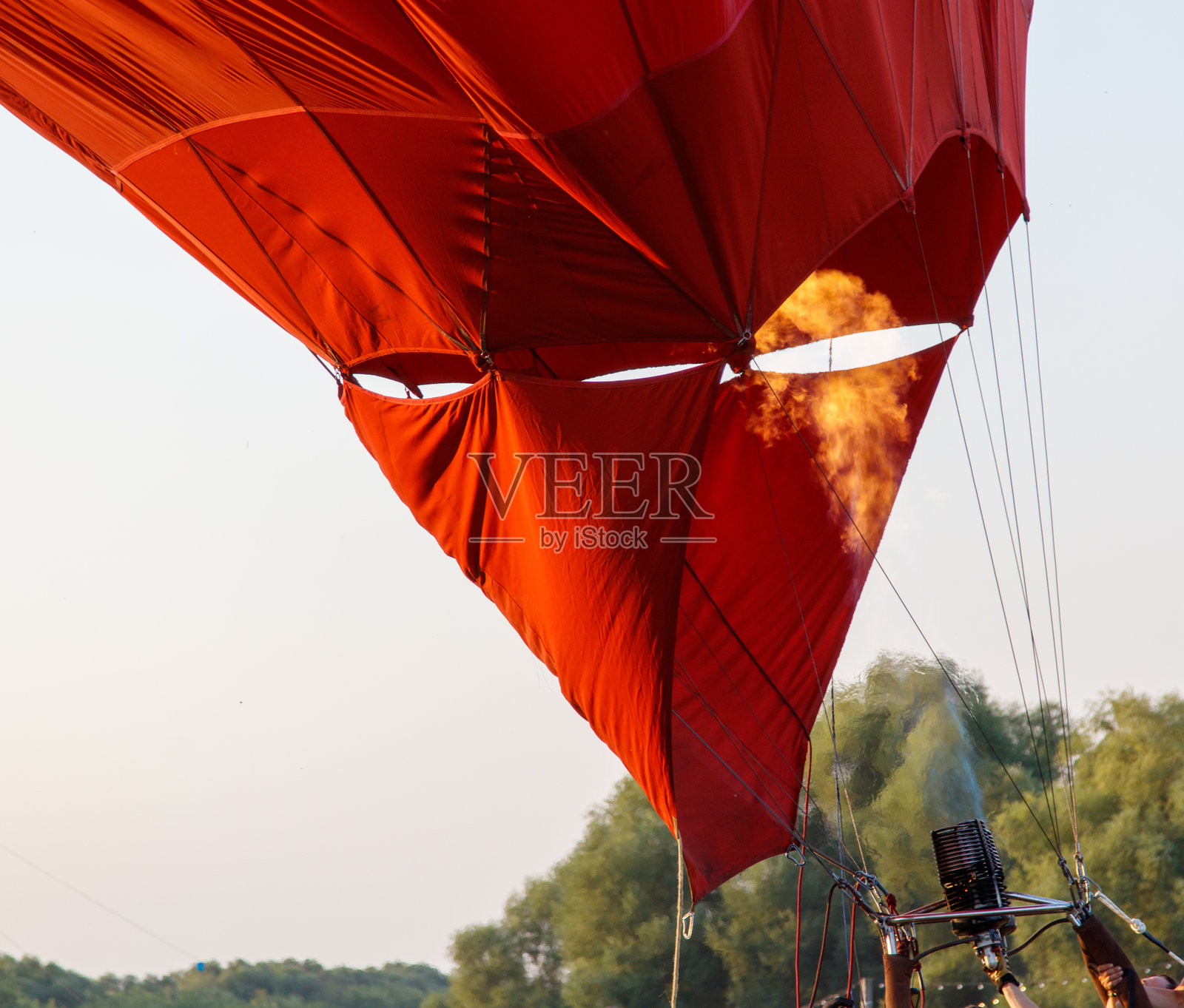 一只红色热气球，火焰从中喷射而出照片摄影图片