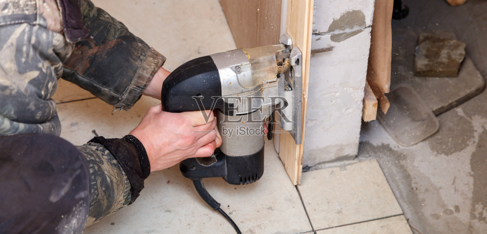 一个男人正在使用电动工具切割一块木头照片摄影图片