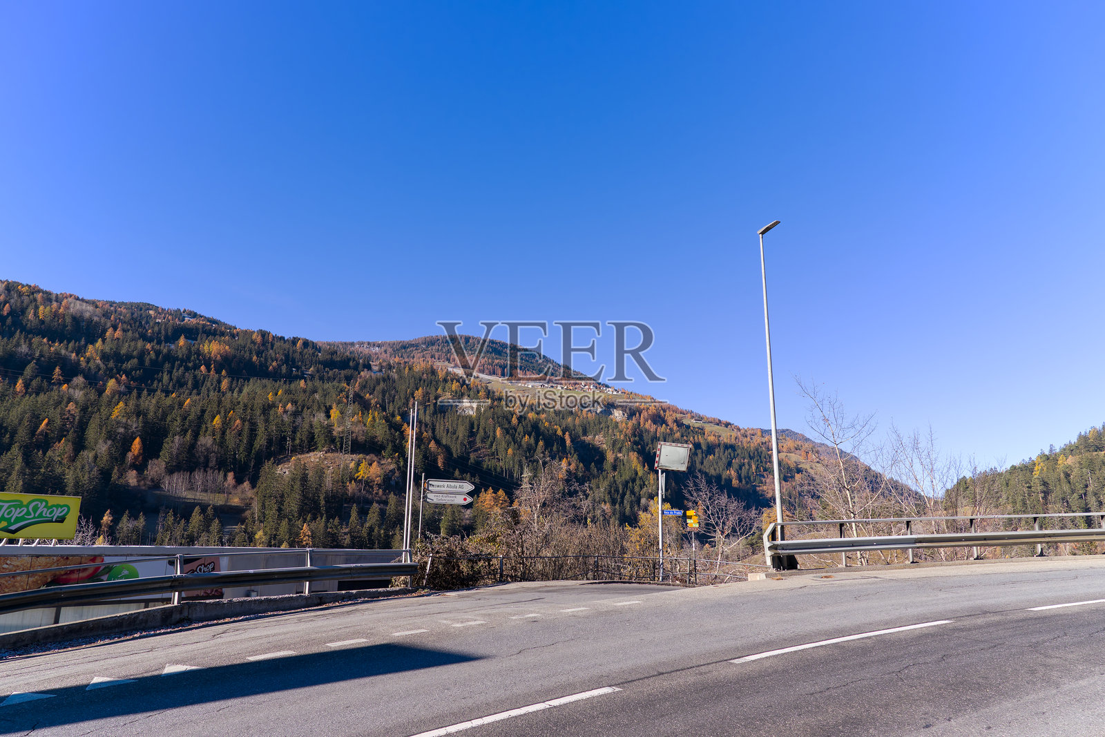 瑞士蒂芬卡斯特尔山村的风景如画的道路，阳光明媚的秋日里有方向指示牌。照片摄影图片