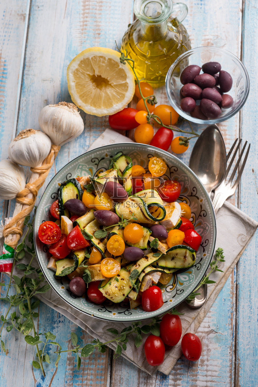 鸡肉沙拉配西葫芦、樱桃番茄、黑橄榄和柠檬照片摄影图片