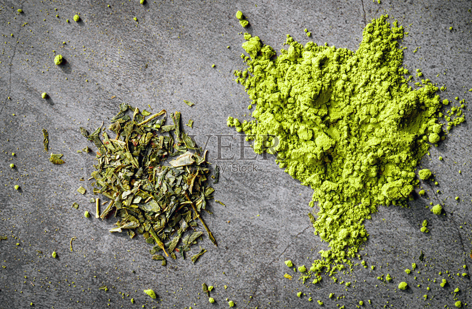 日本抹茶粉和日本干绿茶叶用于健康冲泡，灰色背景上的抹茶和日本干绿茶叶特写照片摄影图片