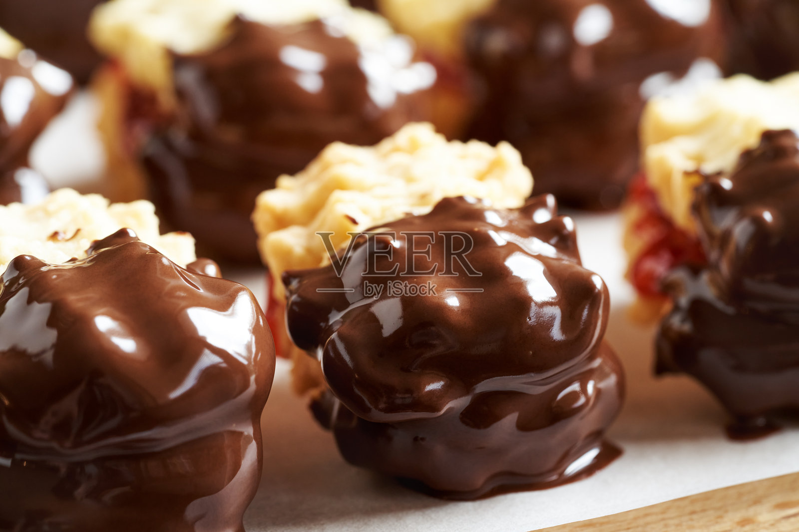 自制的圣诞饼干，夹有草莓果酱并浸泡在巧克力中照片摄影图片