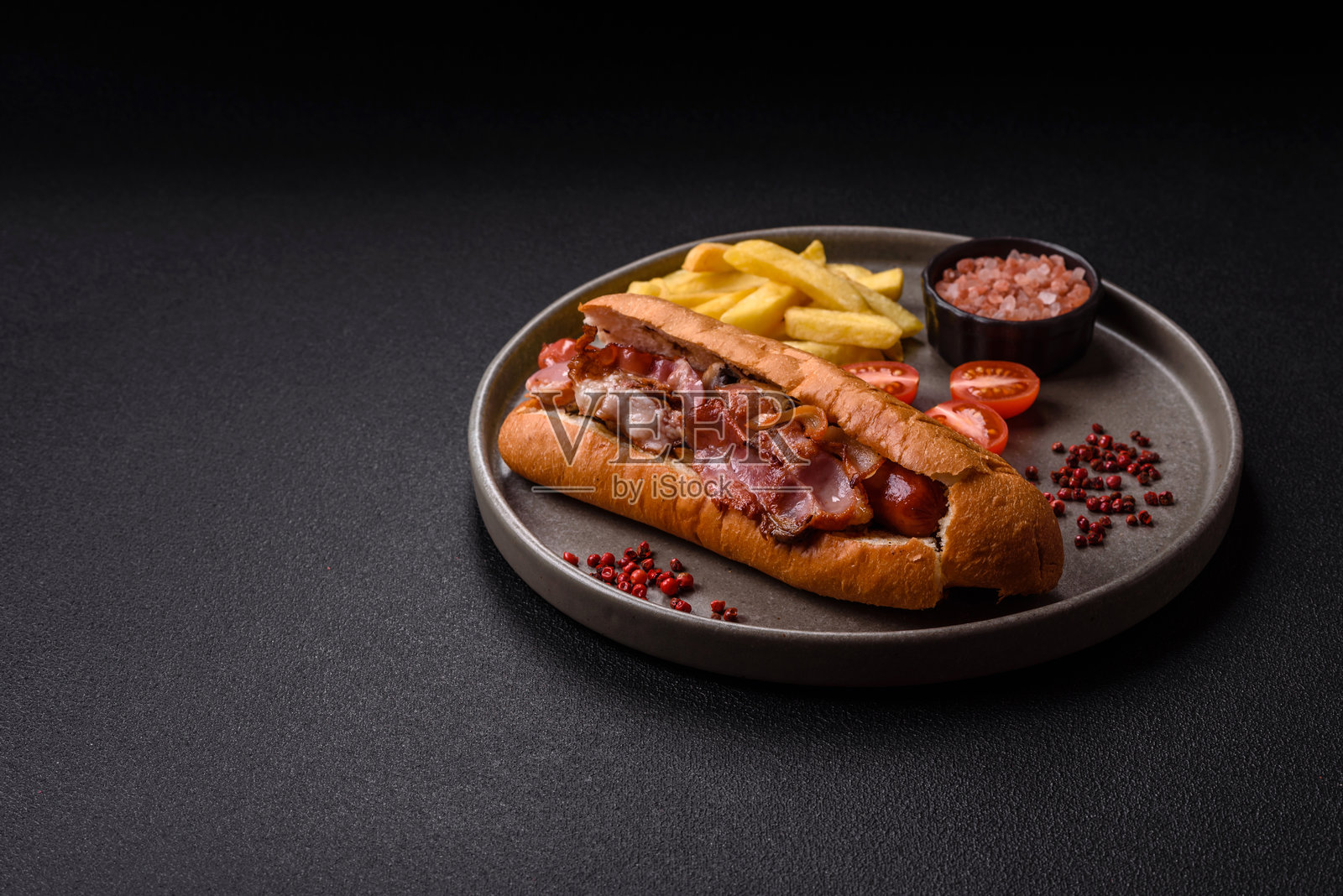 美味多汁的热狗，配有香肠、培根、酱汁、盐和香料照片摄影图片