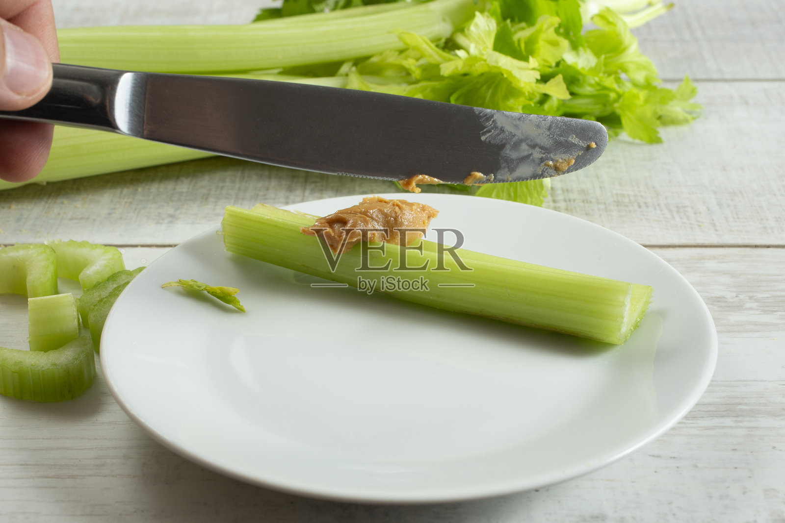 在芹菜上涂抹花生酱照片摄影图片
