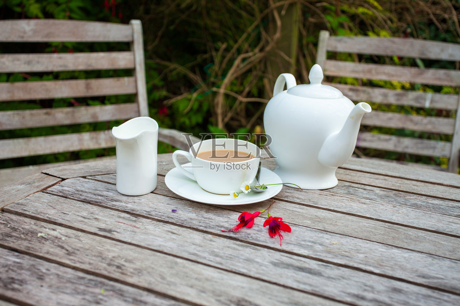 带花的茶杯和茶壶放在乡村风格的木桌上照片摄影图片