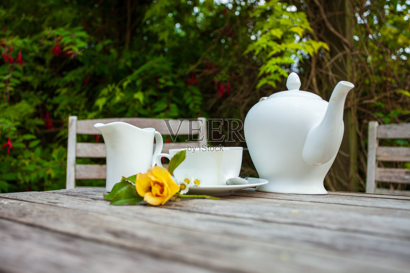 带花的茶杯和茶壶放在乡村风格的木桌上照片摄影图片