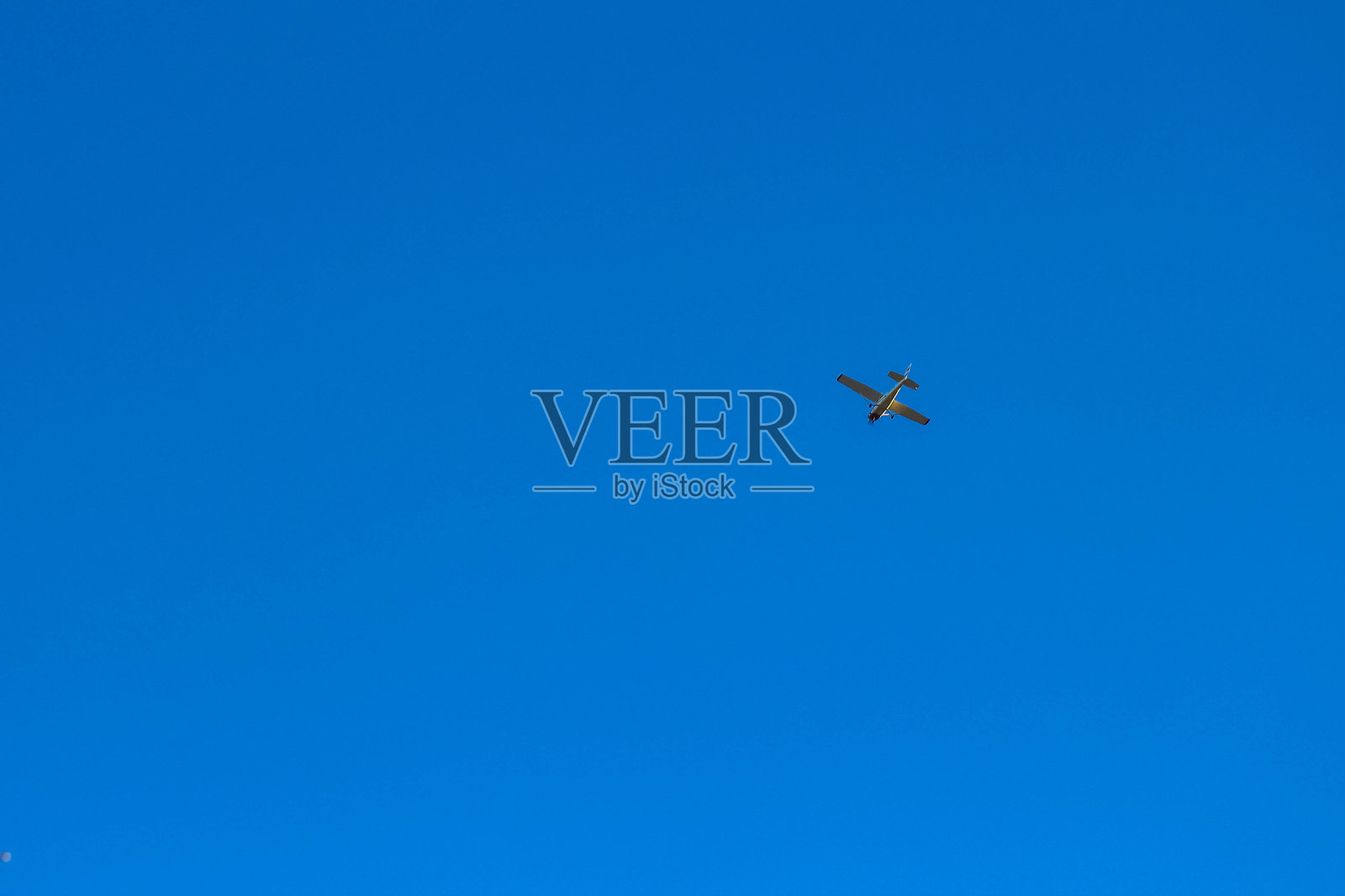 小型飞机在晴朗的蓝天中高飞照片摄影图片