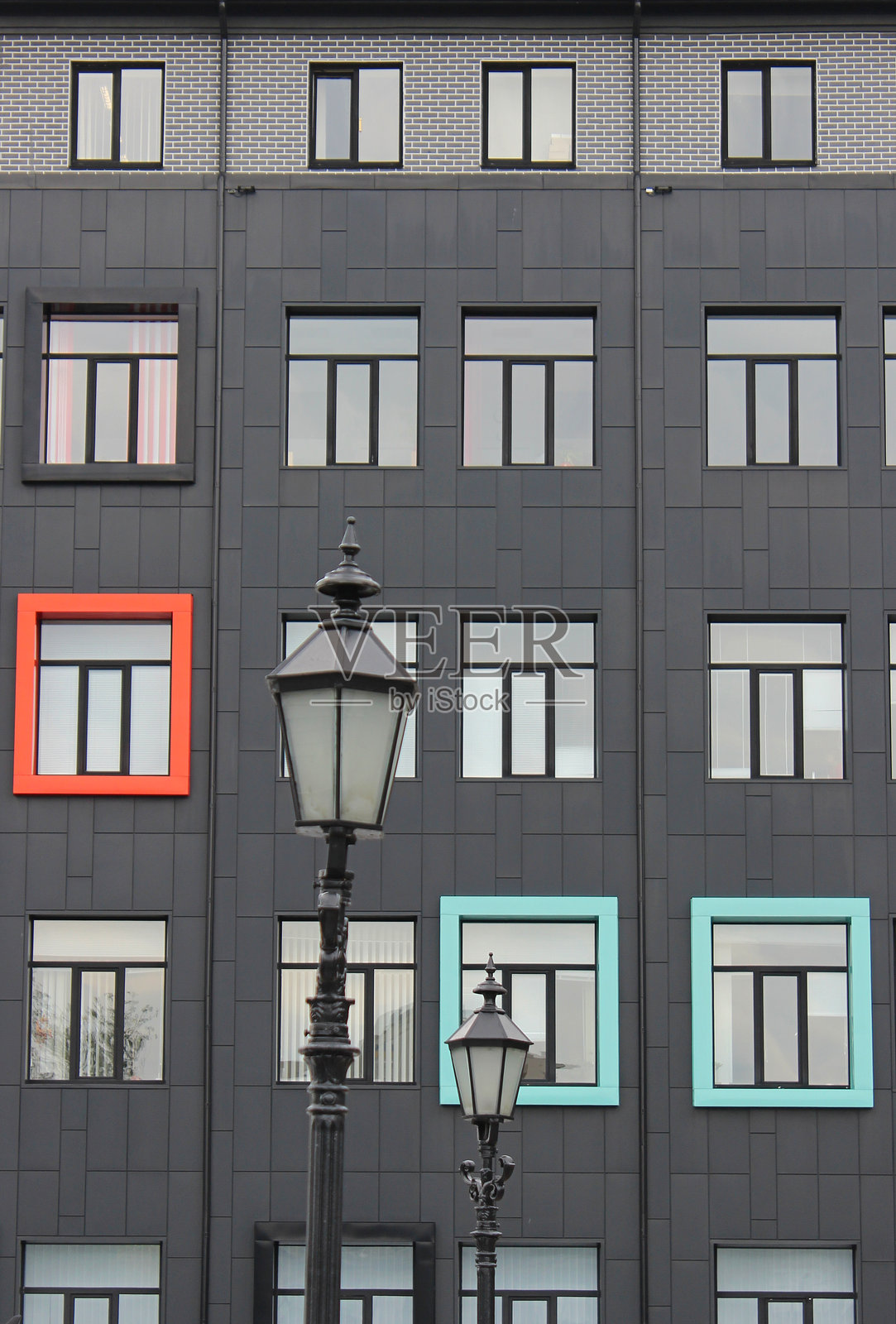 一座商业中心的外立面，前面有彩色框架和古典风格的灯柱。照片摄影图片