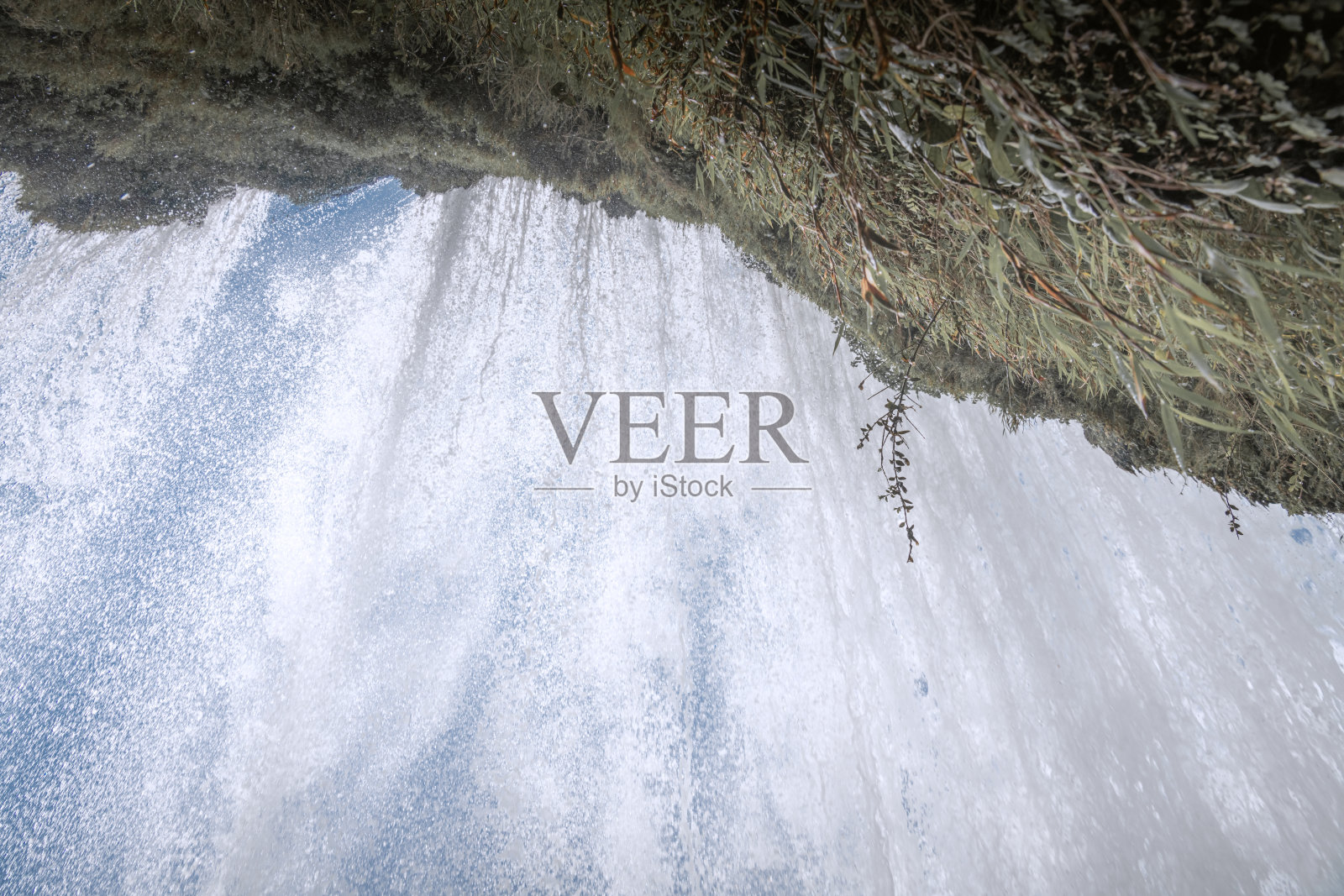 中国贵州的黄果树大瀑布下，水从悬崖上倾泻而下。照片摄影图片