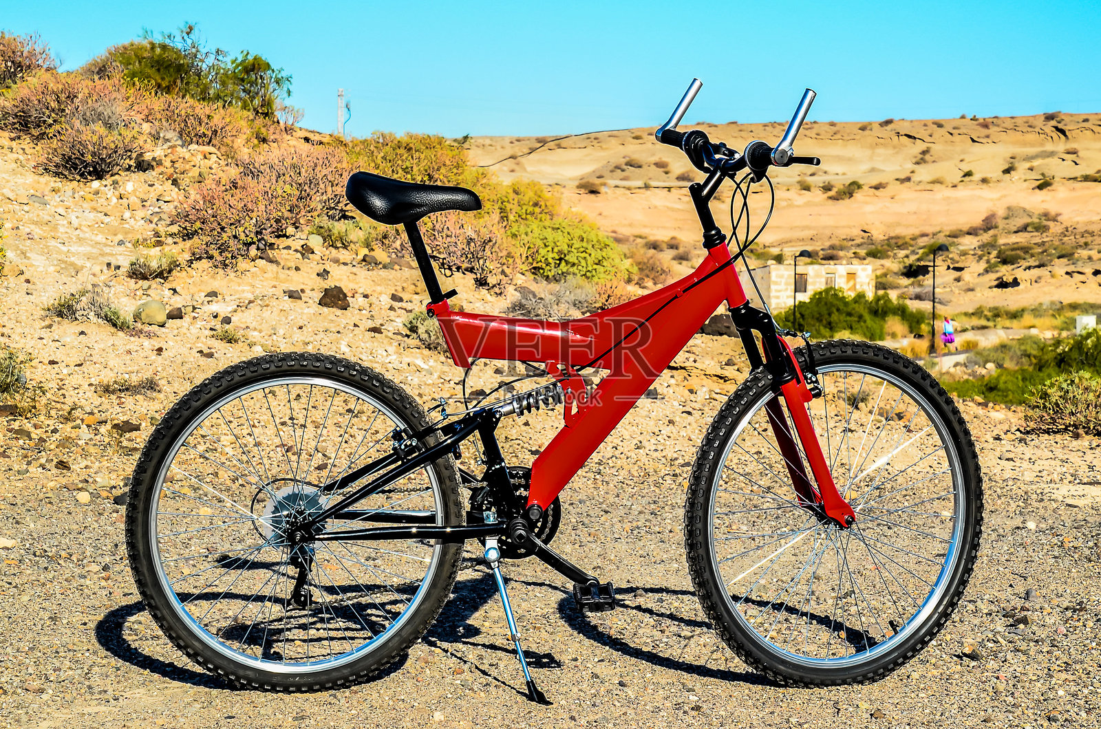 一辆红色山地自行车停在泥土路上照片摄影图片