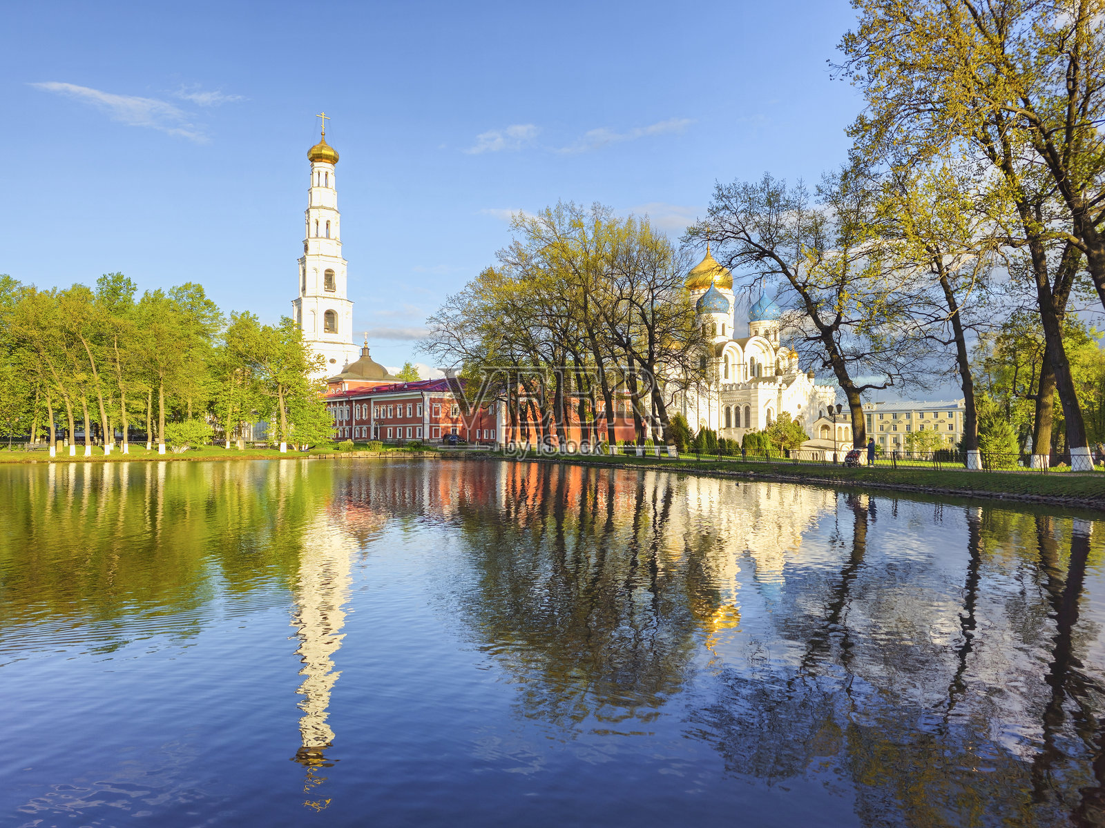 春天的古老教堂与池塘中的倒影。照片摄影图片