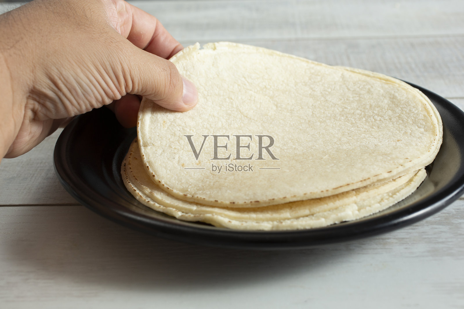 手拿起一些玉米饼照片摄影图片