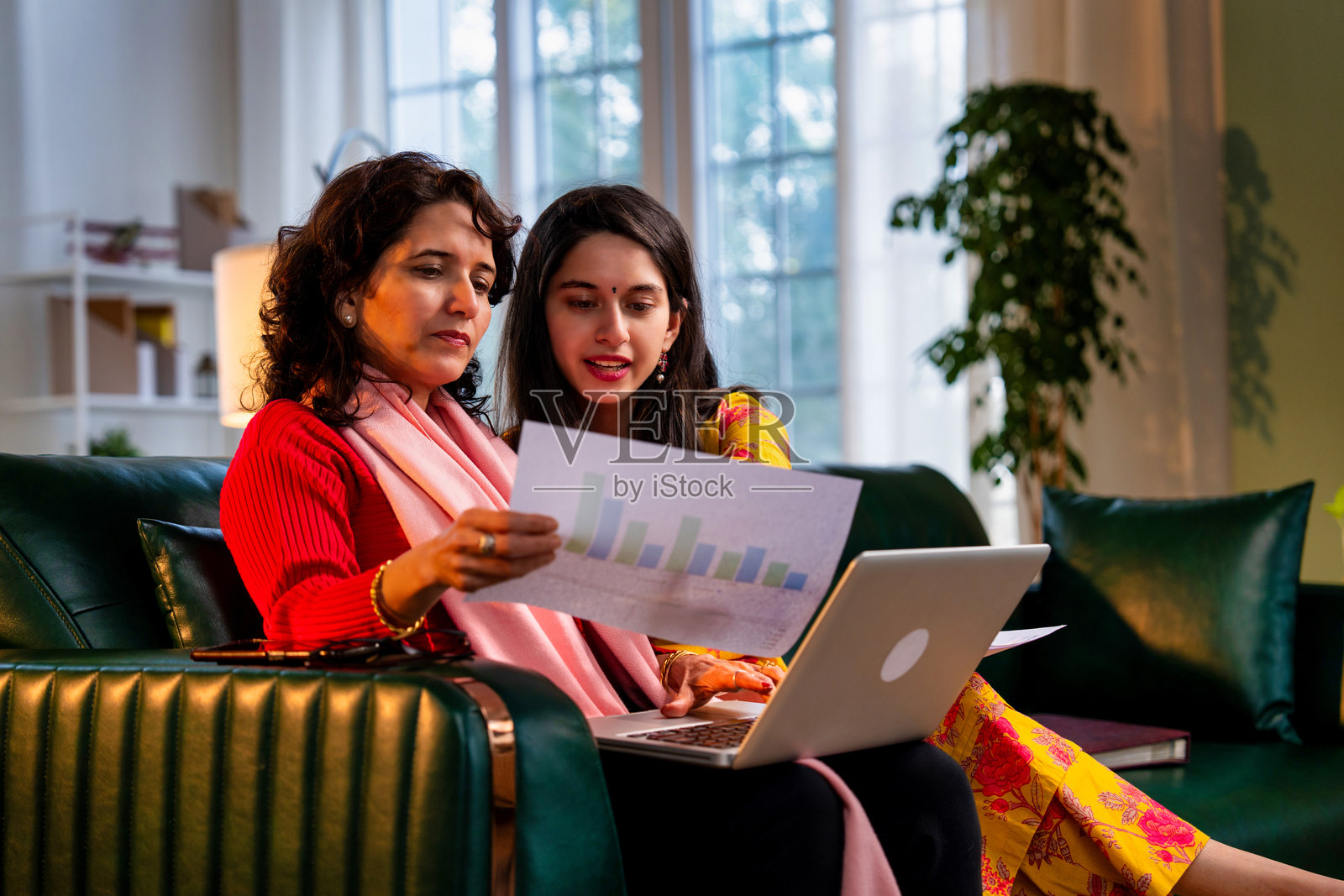 印度母女在家用笔记本电脑管理财务，展现团队合作精神照片摄影图片