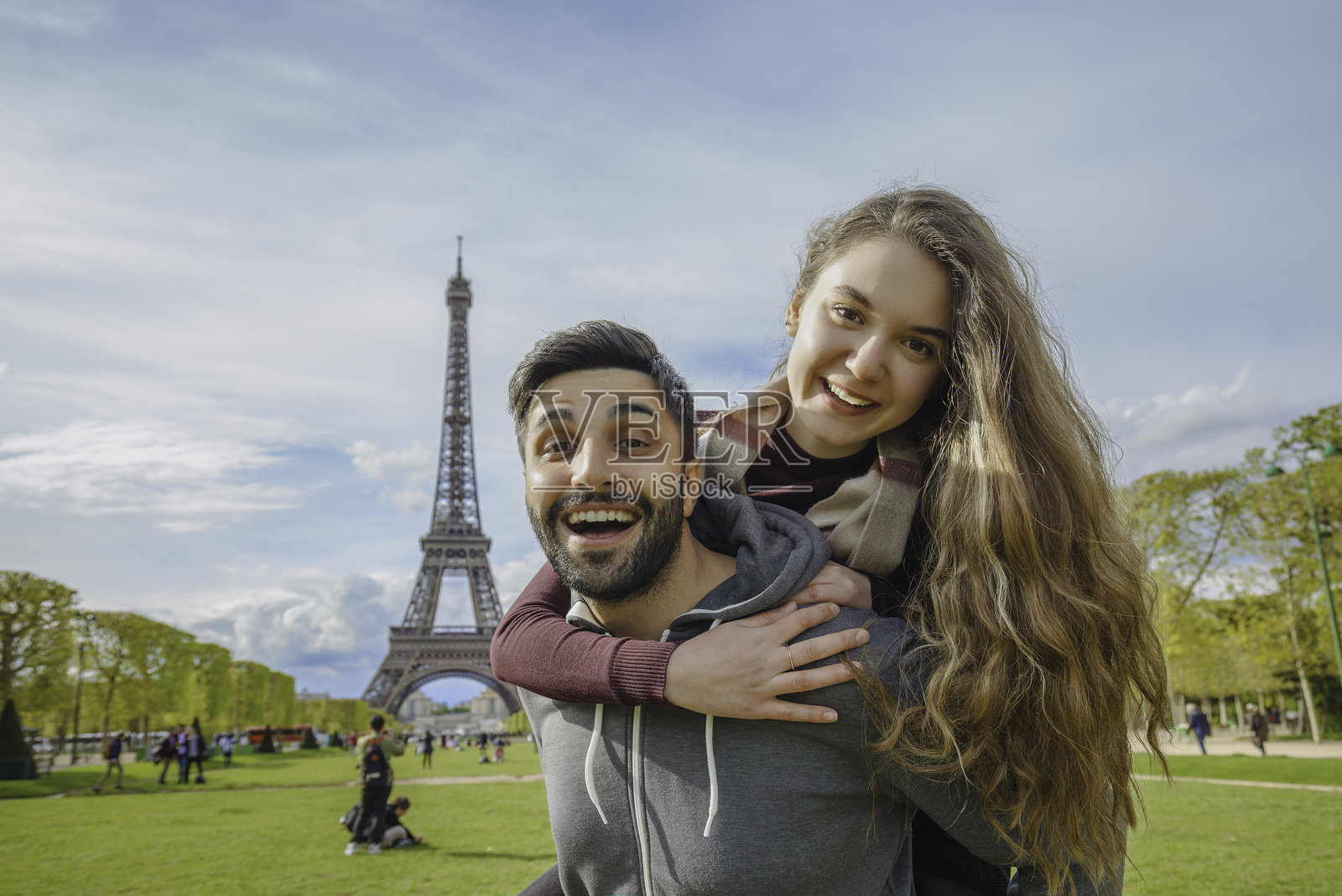 浪漫情侣在法国巴黎埃菲尔铁塔前快乐地摆姿势照片摄影图片