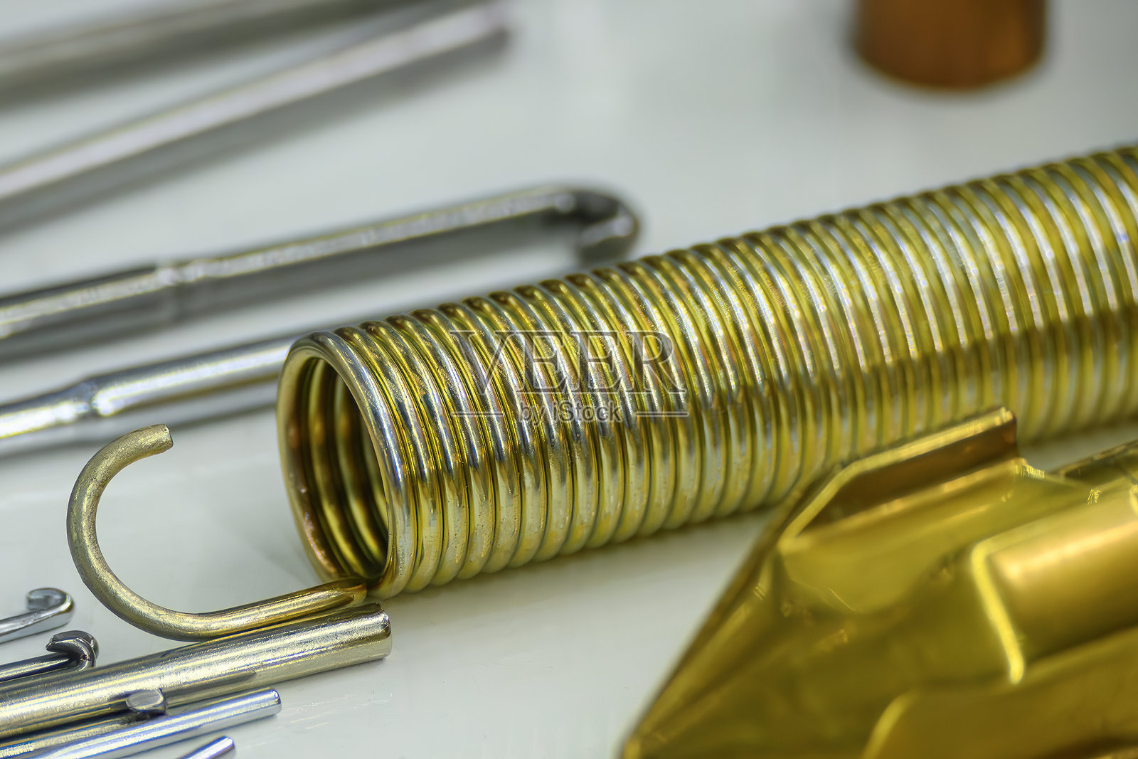 浅蓝色场景中的拉紧线圈弹簧。照片摄影图片