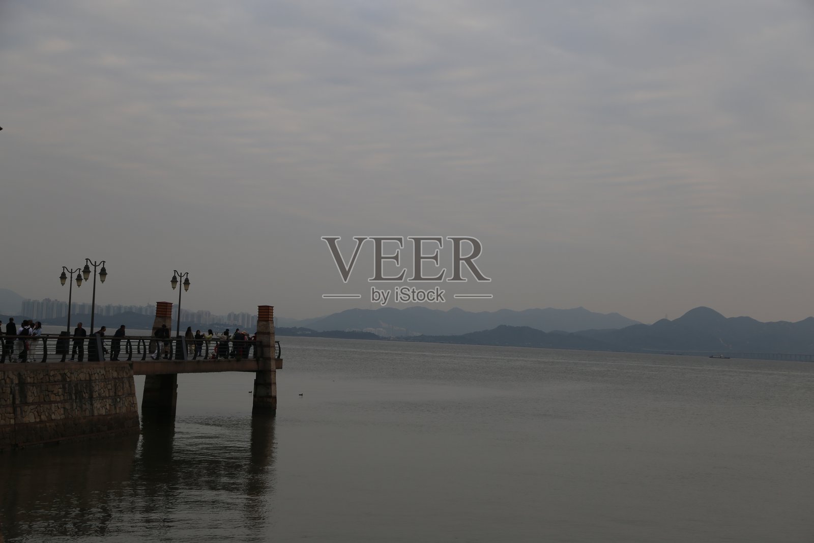 远处是一望无际的大海，面前是巍峨的山脉。照片摄影图片