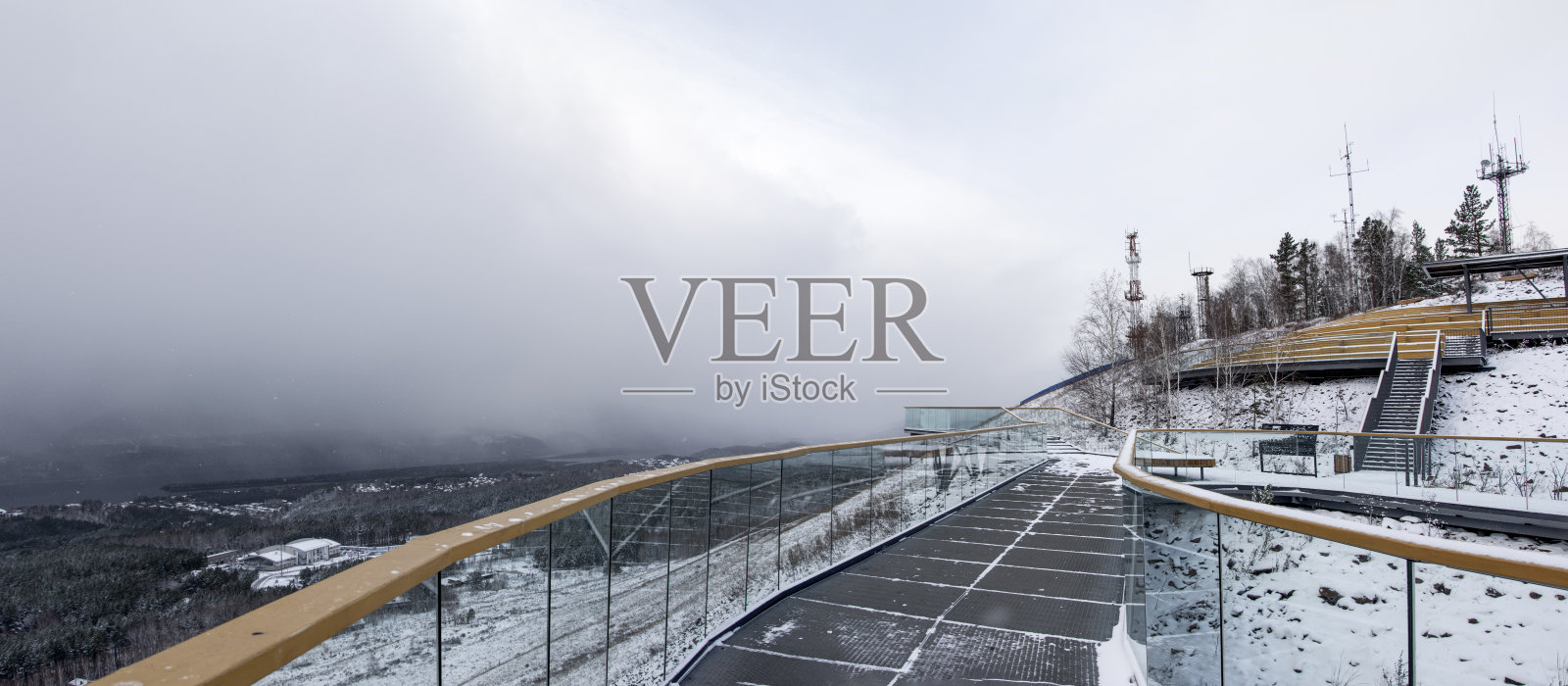 冬季阴沉天气下，山顶观景台与森林的全景视野照片摄影图片
