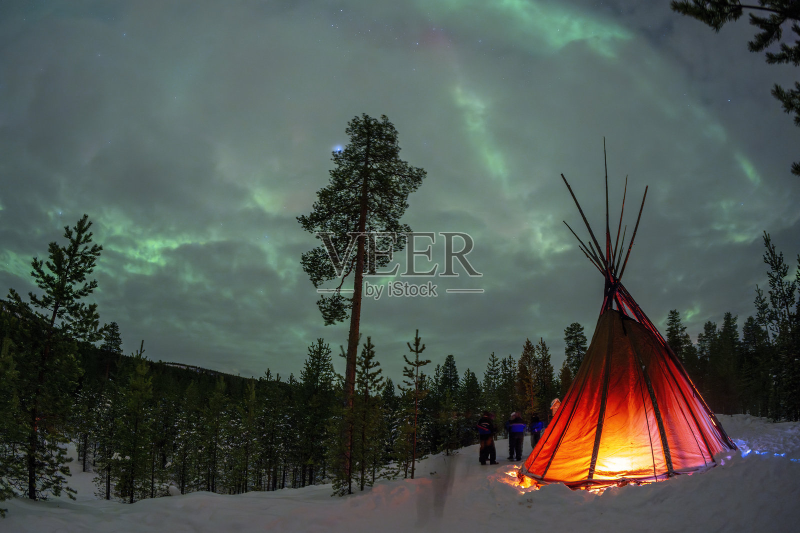 拉普兰伊纳里内林湖森林中的萨米帐篷与北极光照片摄影图片