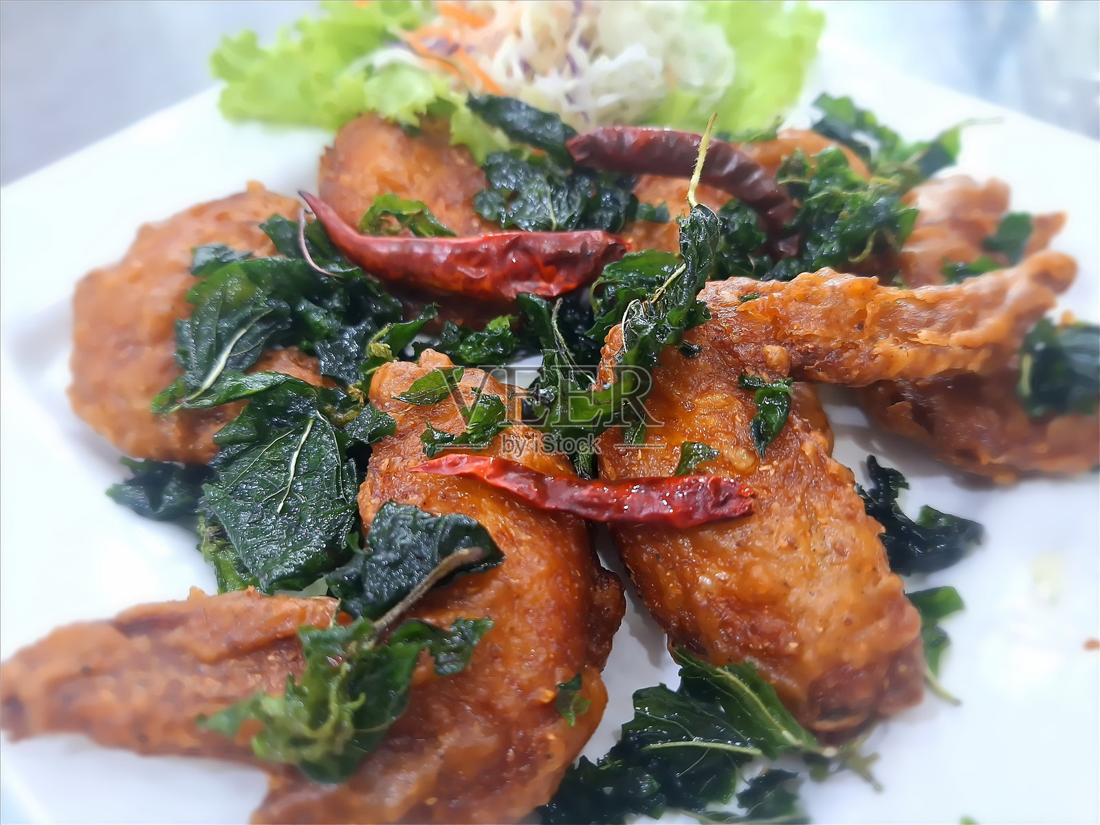 炸鸡翅配脆香罗勒叶和干辣椒照片摄影图片