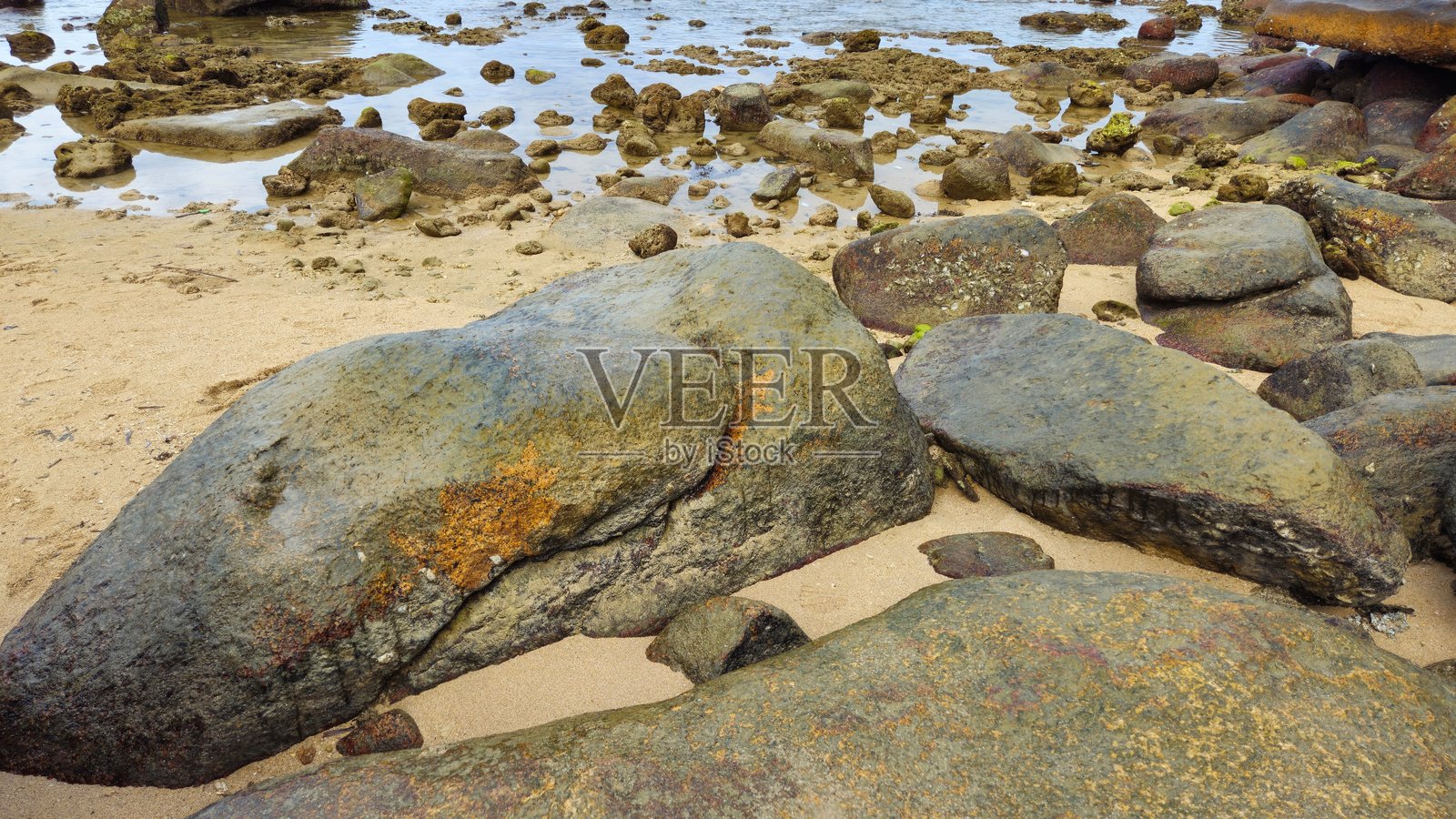 越南芽庄沙滩上的洪冲角岩石花园，岩石散布的海岸风景，平静的海面和背景中的山脉。照片摄影图片