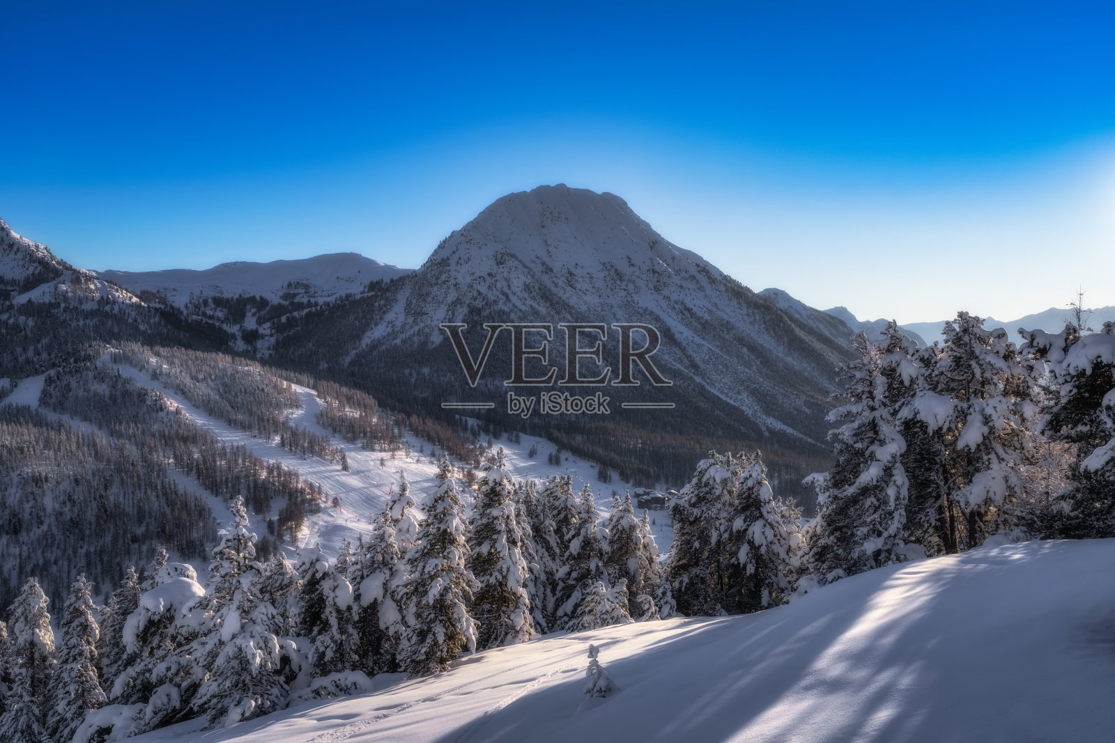 沉浸在雪山和晴朗蓝天的冬季风景的惊人美丽中照片摄影图片