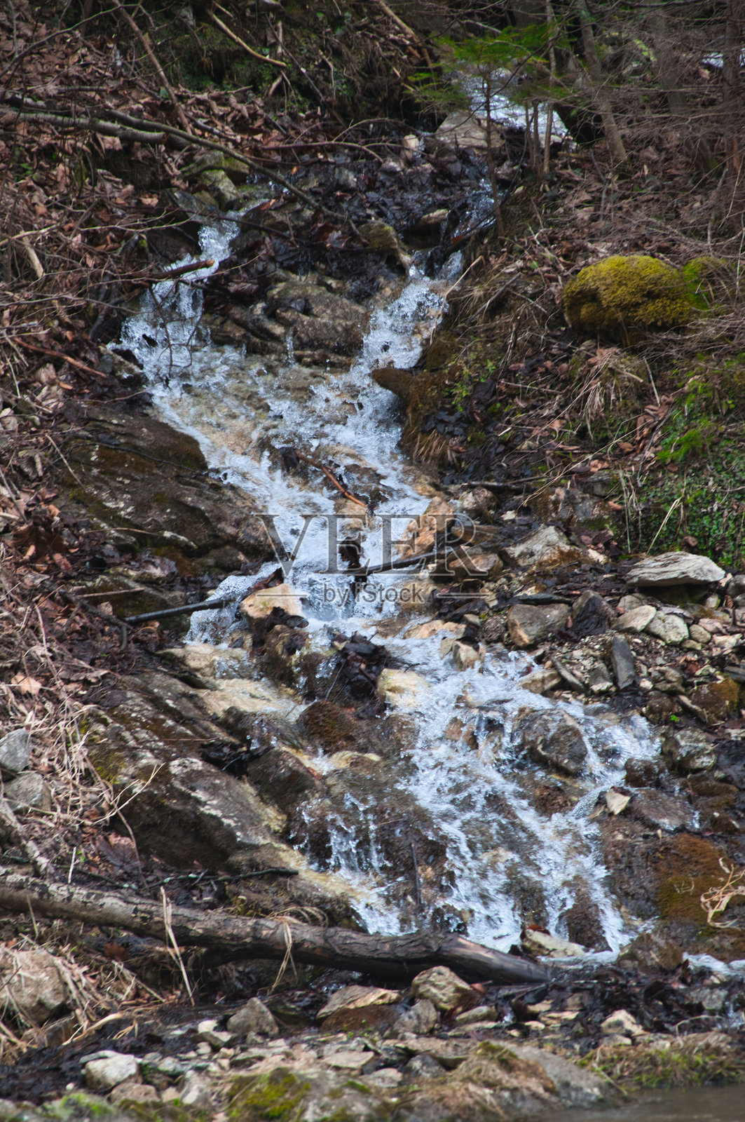 阴天时岩石河岸上的小瀑布照片摄影图片