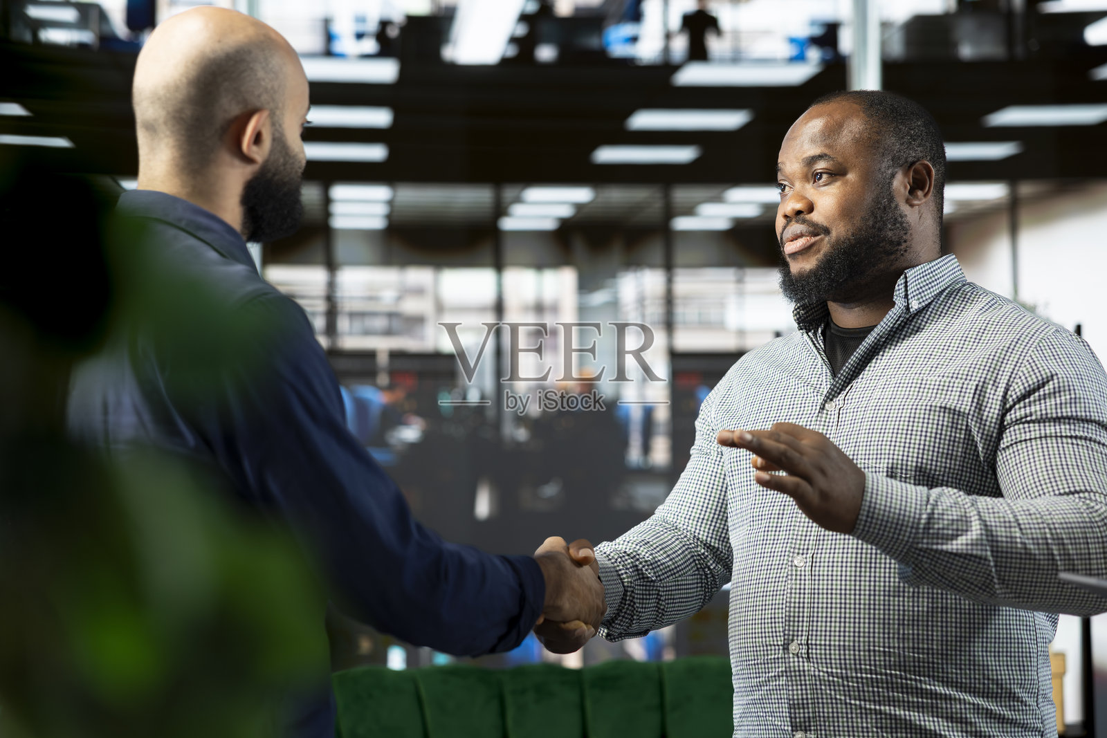 男子与导演交谈，解释创业发展的愿景，并握手。照片摄影图片