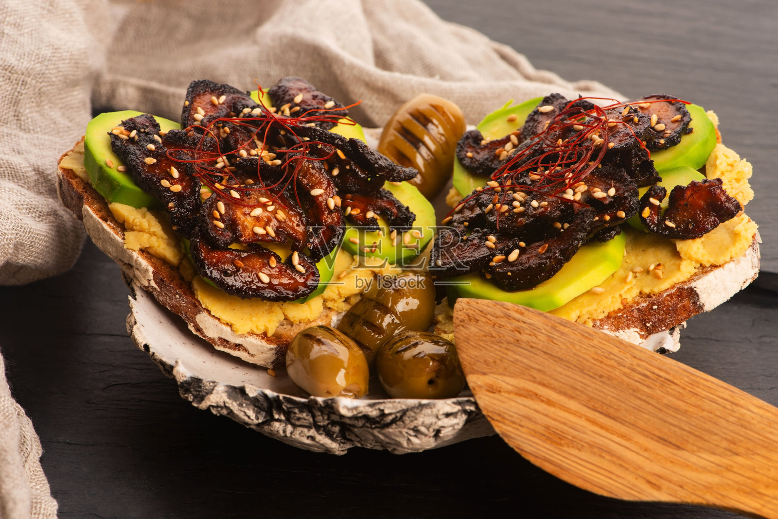 美味的三明治，配有鳄梨、鹰嘴豆泥和焦糖香菇照片摄影图片