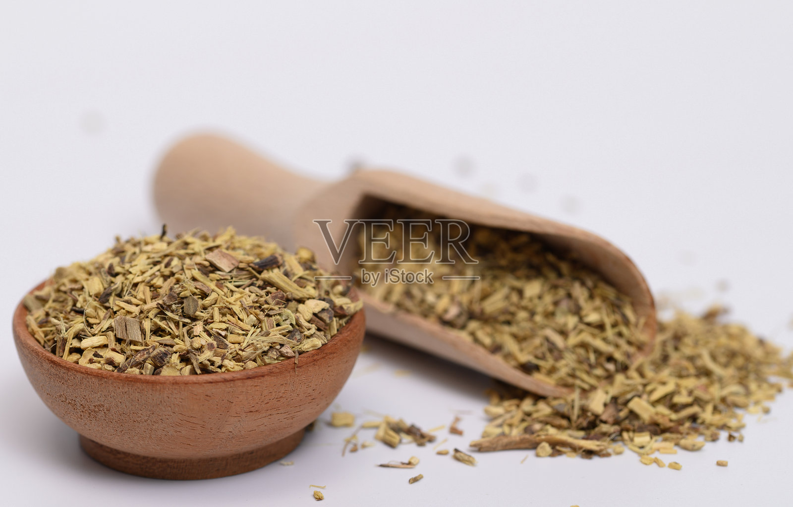 木碗和勺子里的干切甘草根照片摄影图片