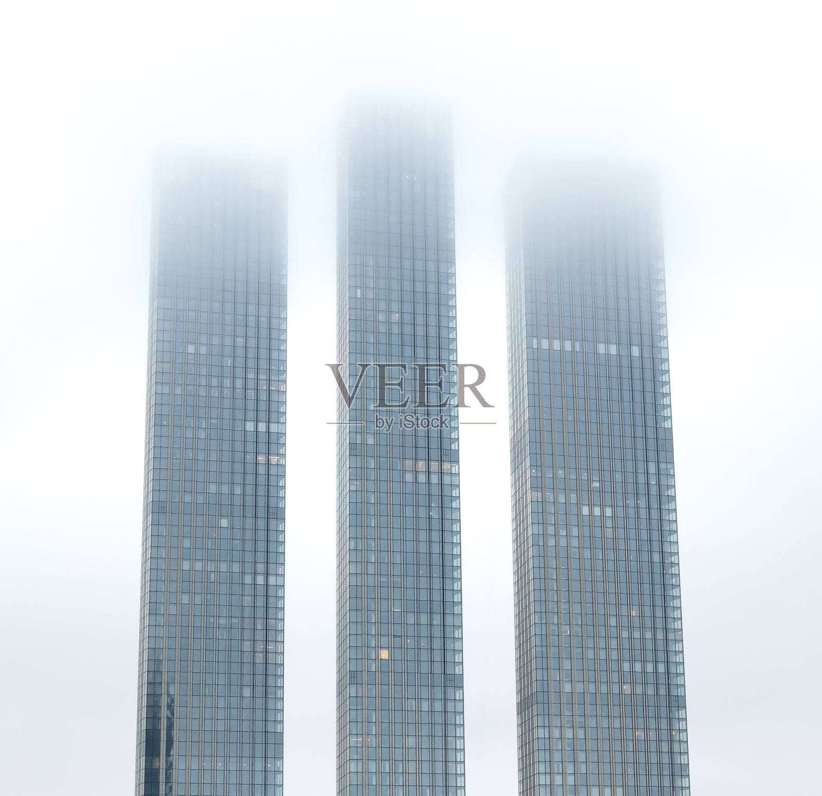 三座高楼大厦与雾霭弥漫的天空相映成趣照片摄影图片