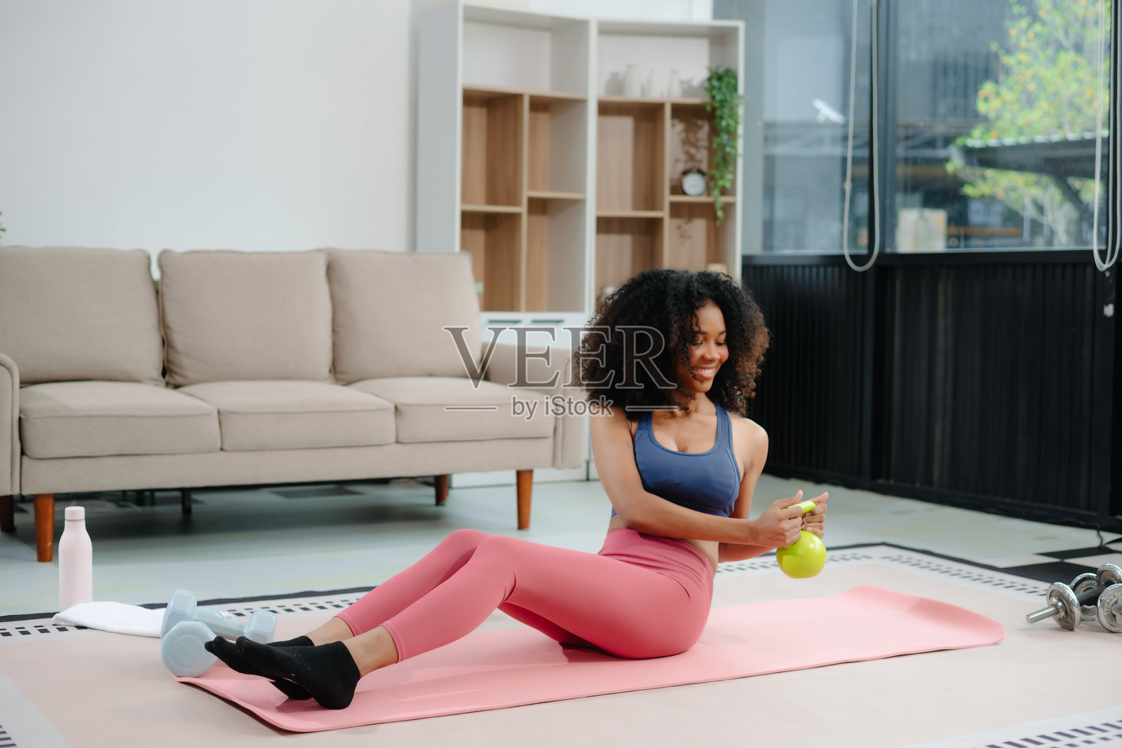 非洲女性在做瑜伽并观看笔记本电脑上的在线教程，进行训练照片摄影图片