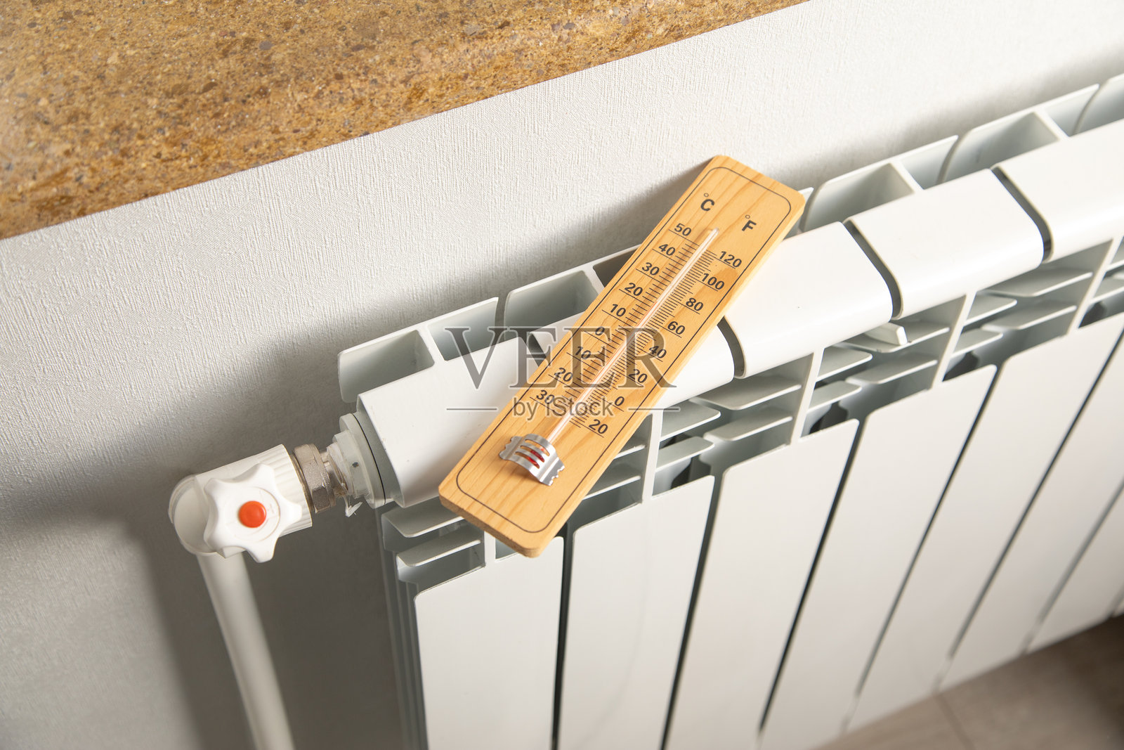 家中暖气散热器上的温度计。照片摄影图片