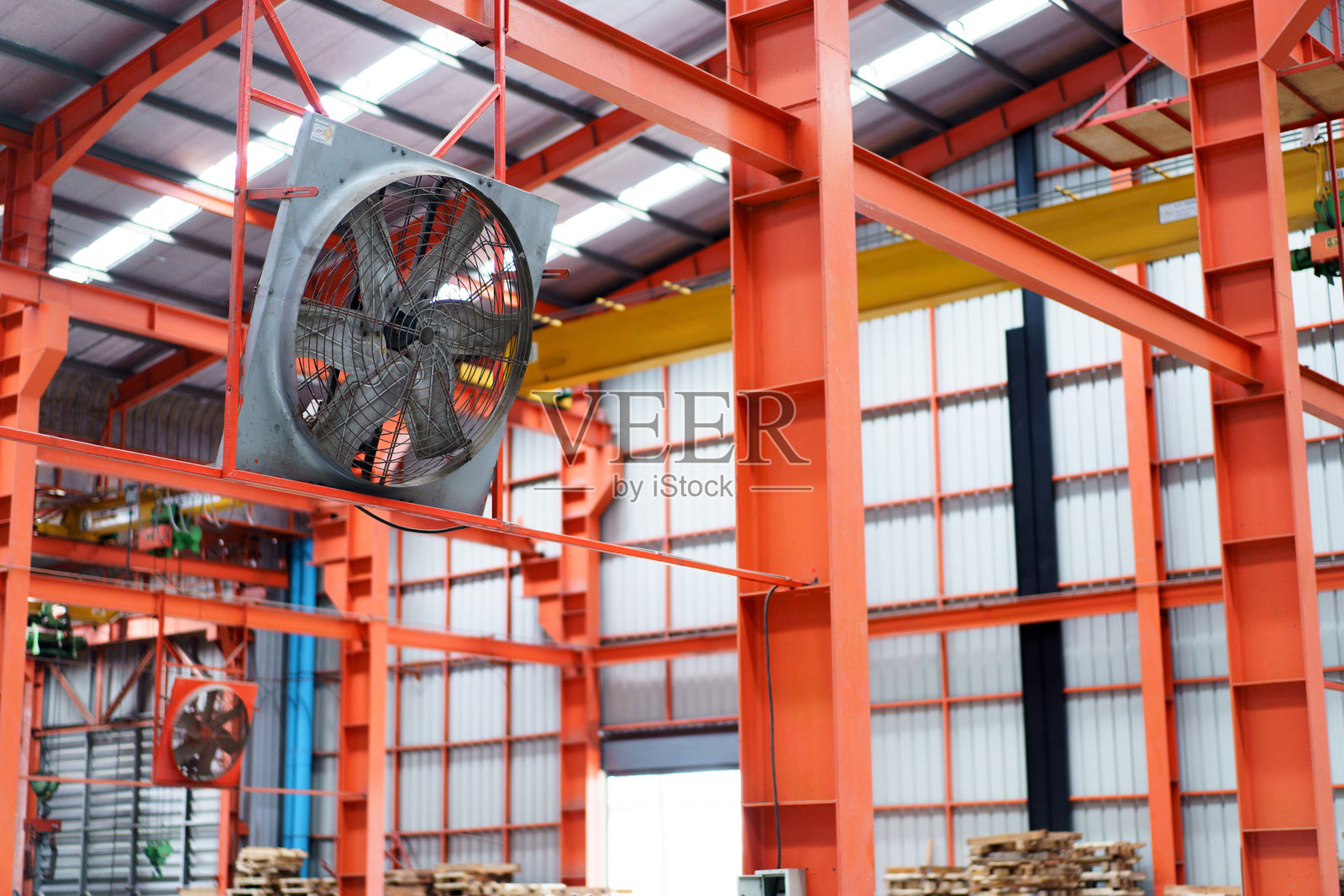 工厂天花板下安装的通风风扇系统。照片摄影图片
