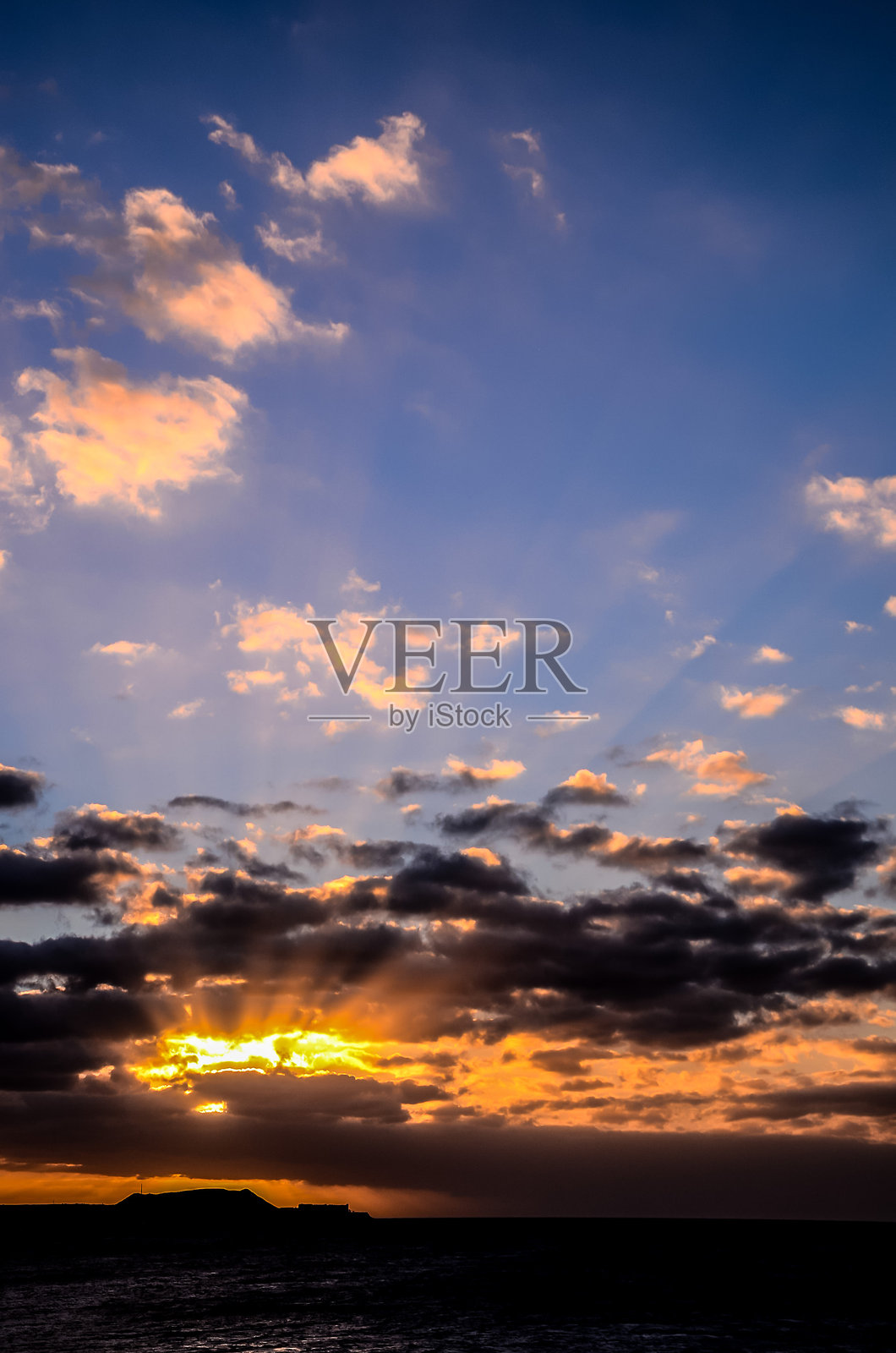 天空布满了云彩，阳光透过云层洒下。照片摄影图片