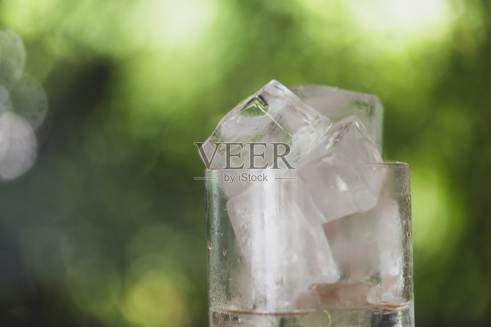 一杯装有自制冰块的水。照片摄影图片