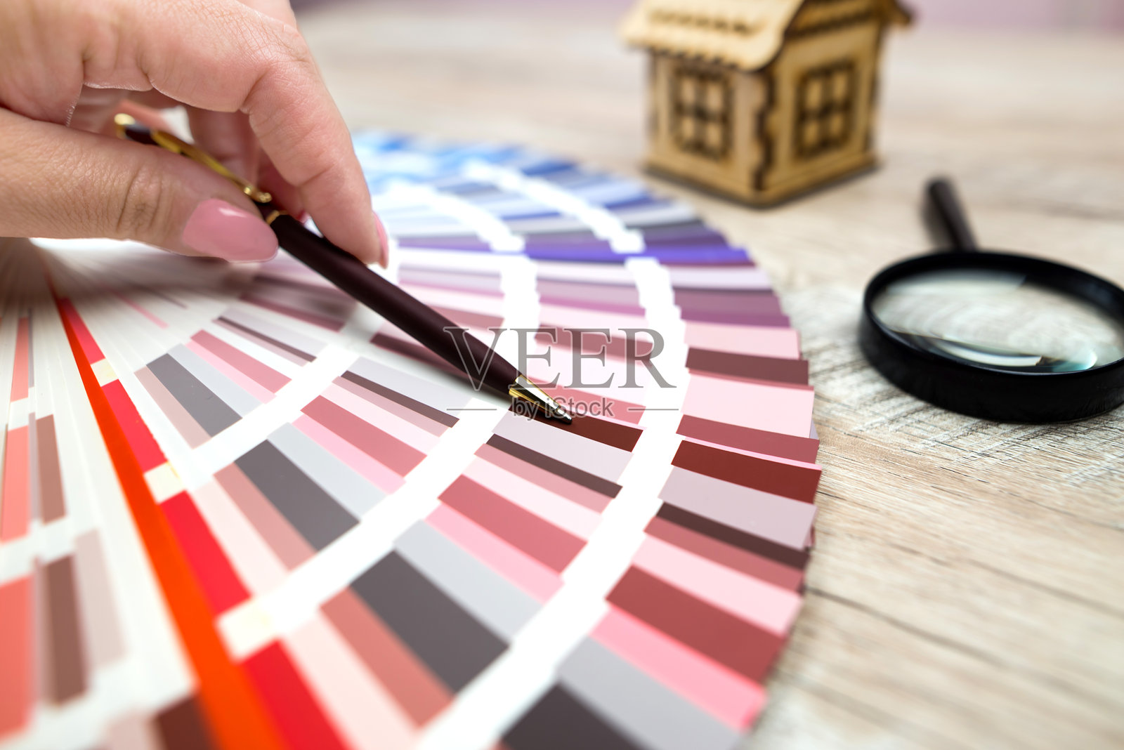 用手指指向调色板中选定颜色的人。彩色样本册。室内设计选择的概念。照片摄影图片