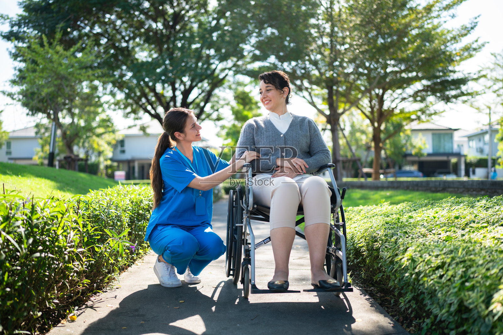 护士在户外与坐轮椅的女性互动照片摄影图片