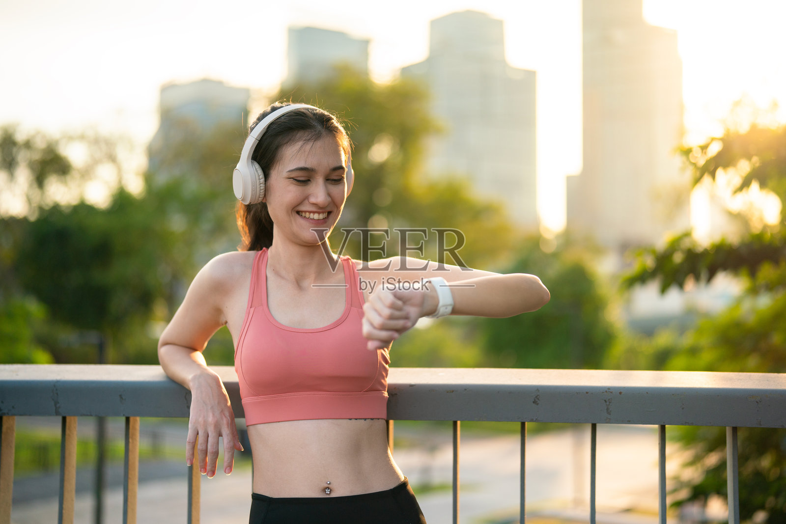 女性在户外锻炼后查看智能手表照片摄影图片